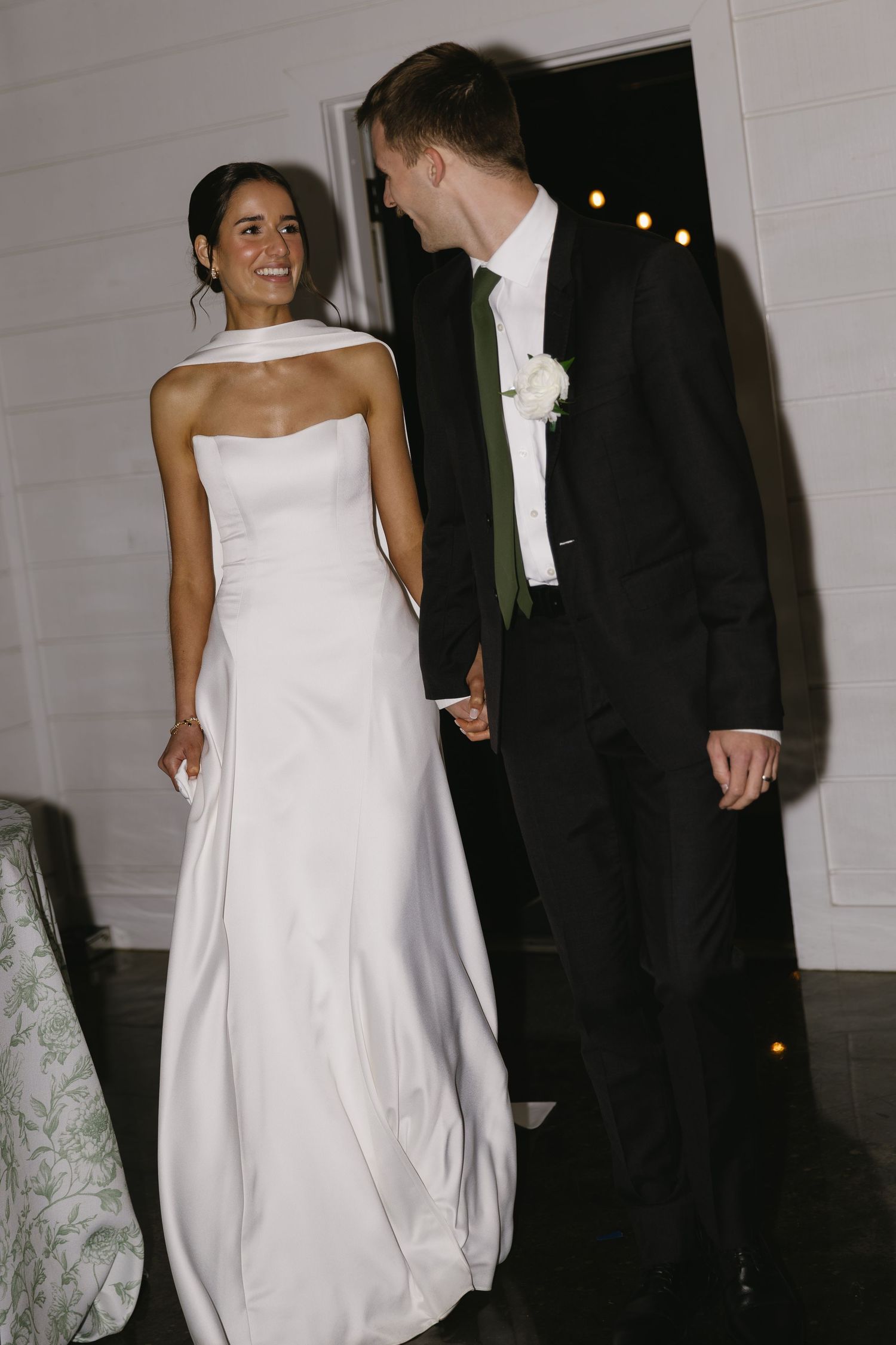 Candid moments of newlyweds dancing and laughing in a white-walled reception venue.