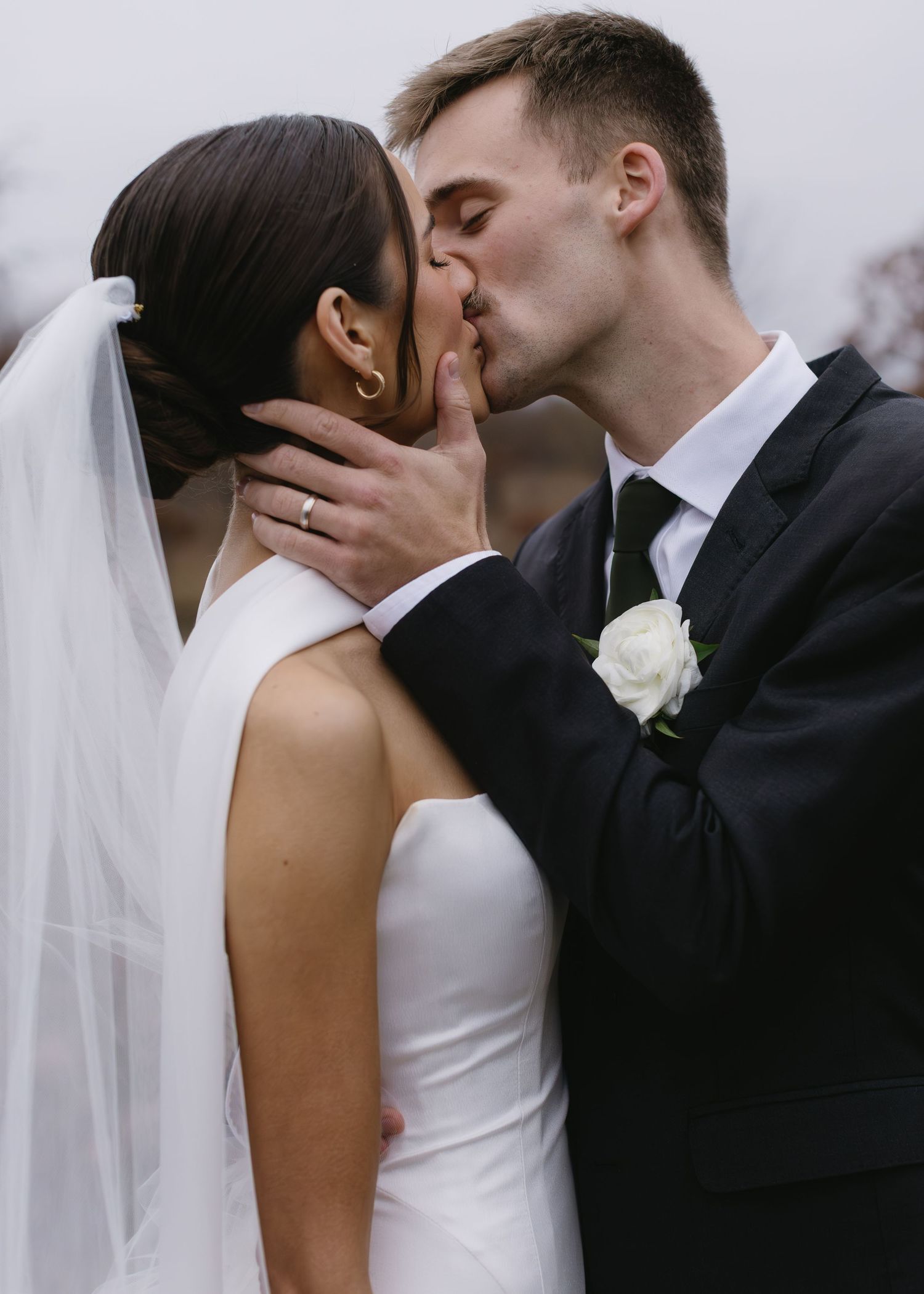 Romantic wedding moment captured in black and white with flowing veil.