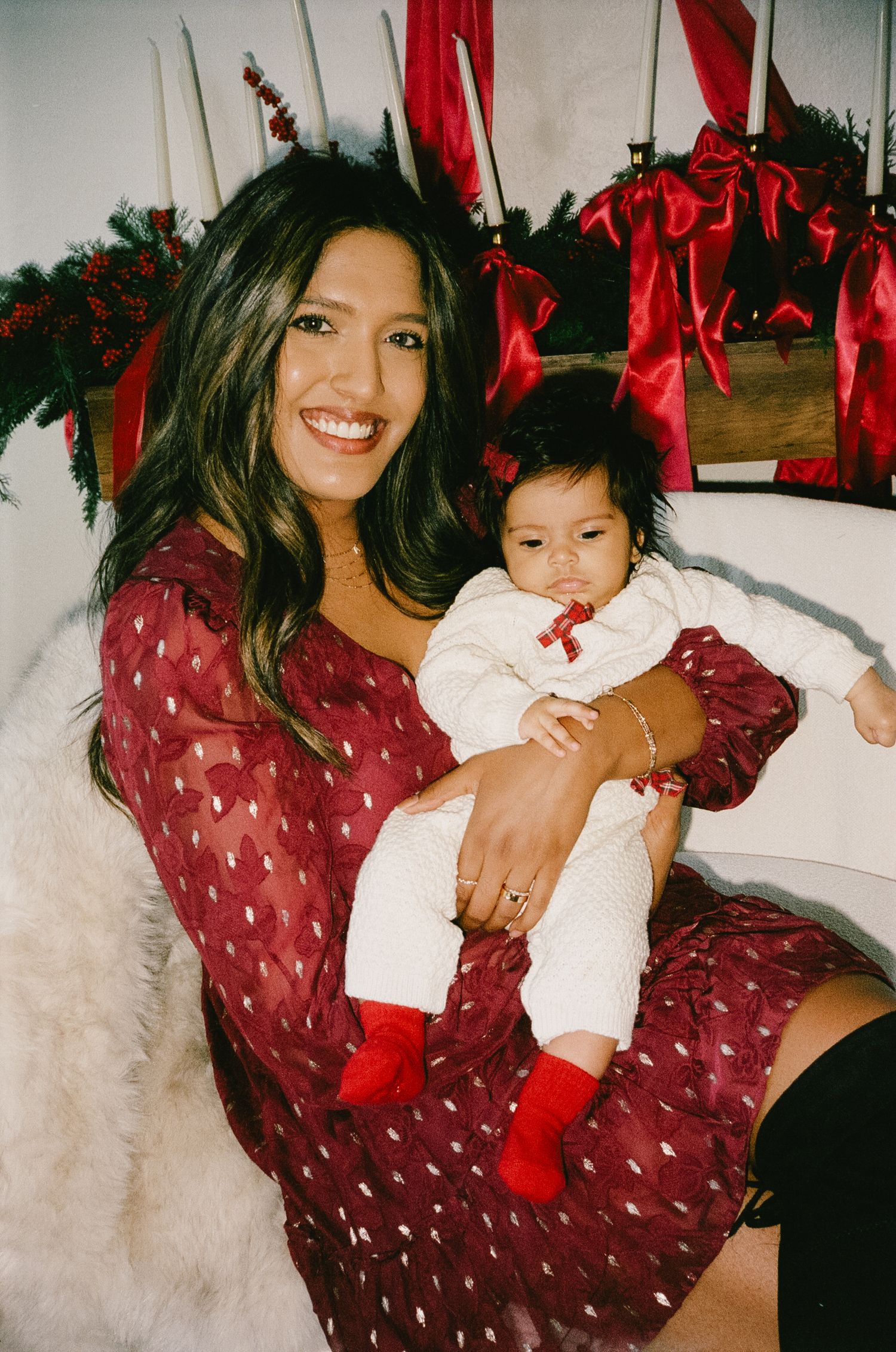 Candid holiday photos with red decorations and a polka dot dress in a bright festive setting.