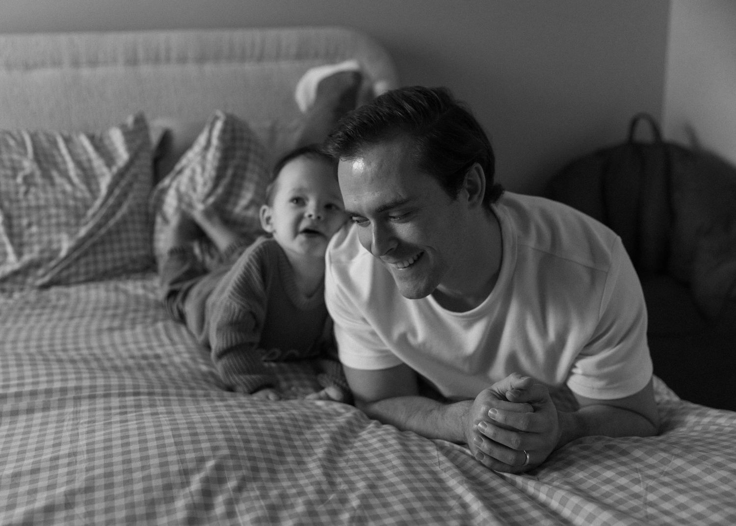 Black and white photo sequence showing a person lying on a bed in various poses with a phone.
