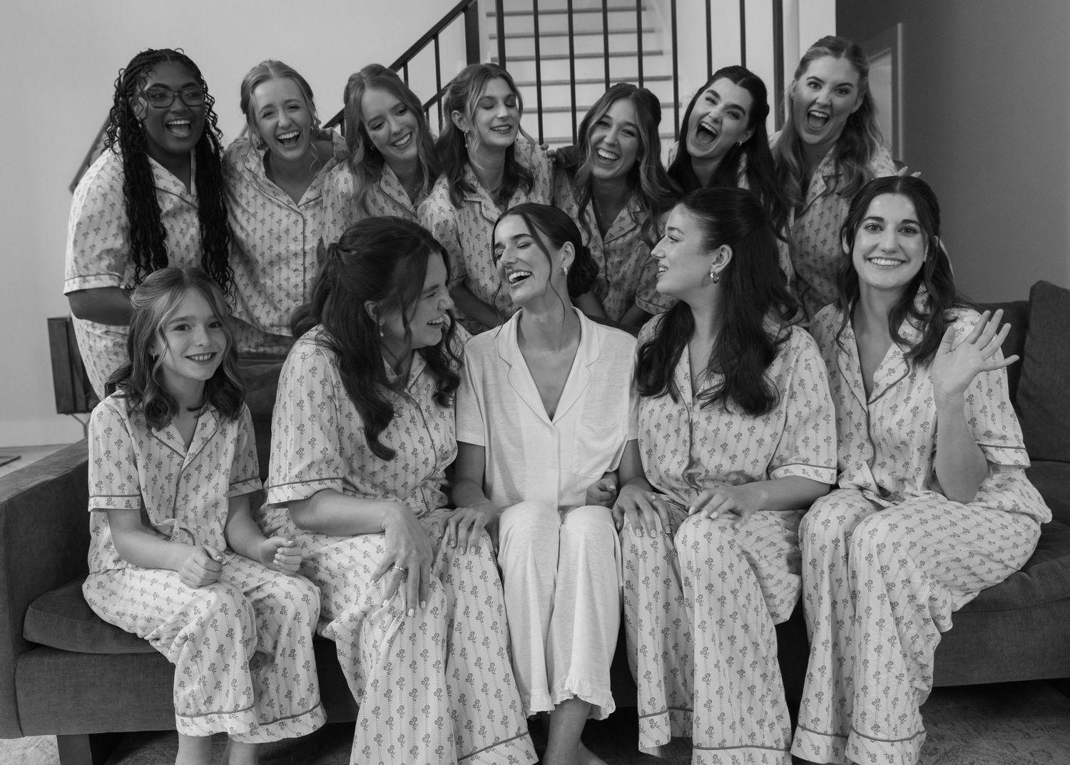 Wedding party wearing matching floral robes poses together during getting ready preparations.