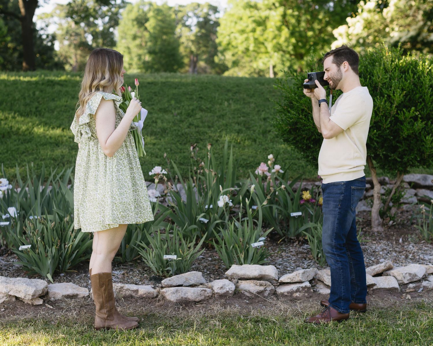Five connected photos show a couple taking turns capturing each other in a spring garden setting with blooming flowers.