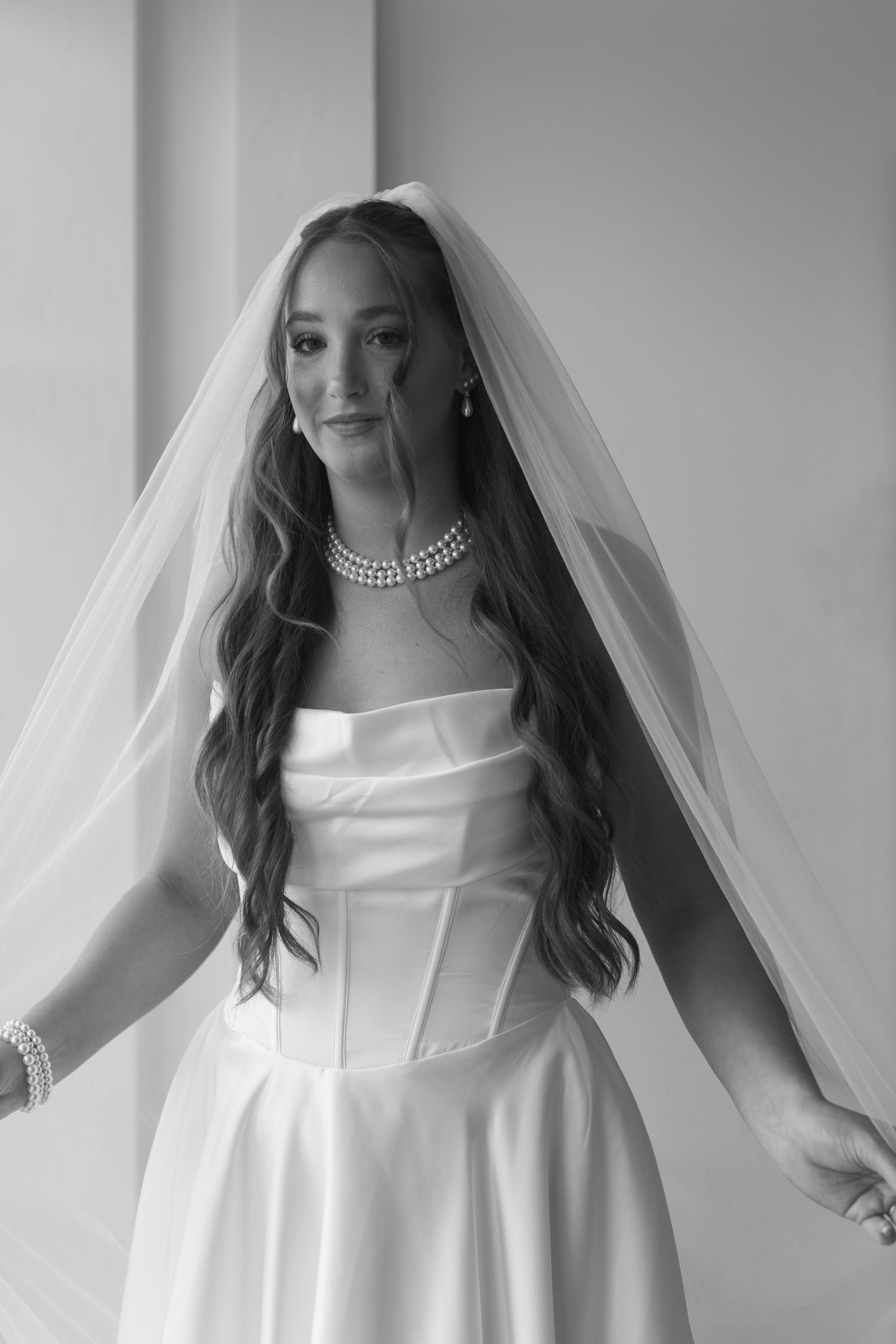A series of black and white portraits showing a bride in a stunning white wedding gown and veil.