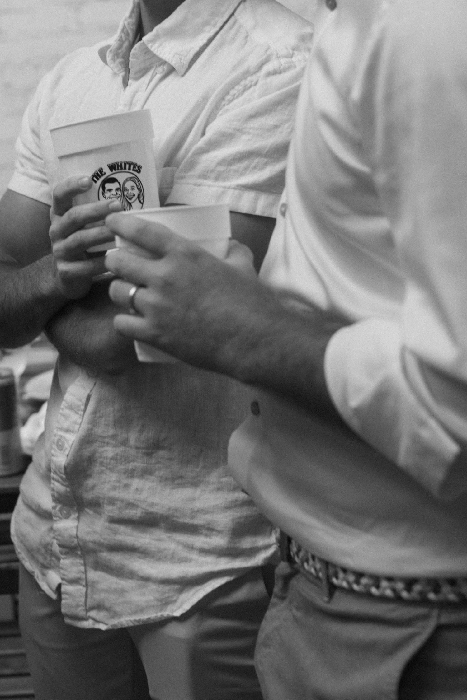 A group of people in white shirts talking and gesturing at a casual gathering.
