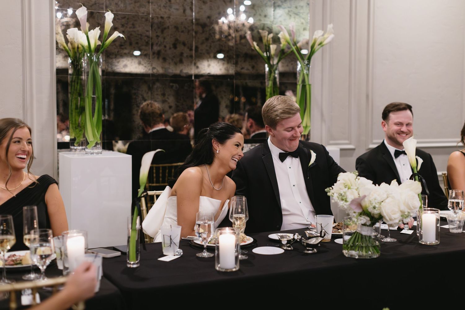 Wedding reception dinner with elegant table settings and floral centerpieces.