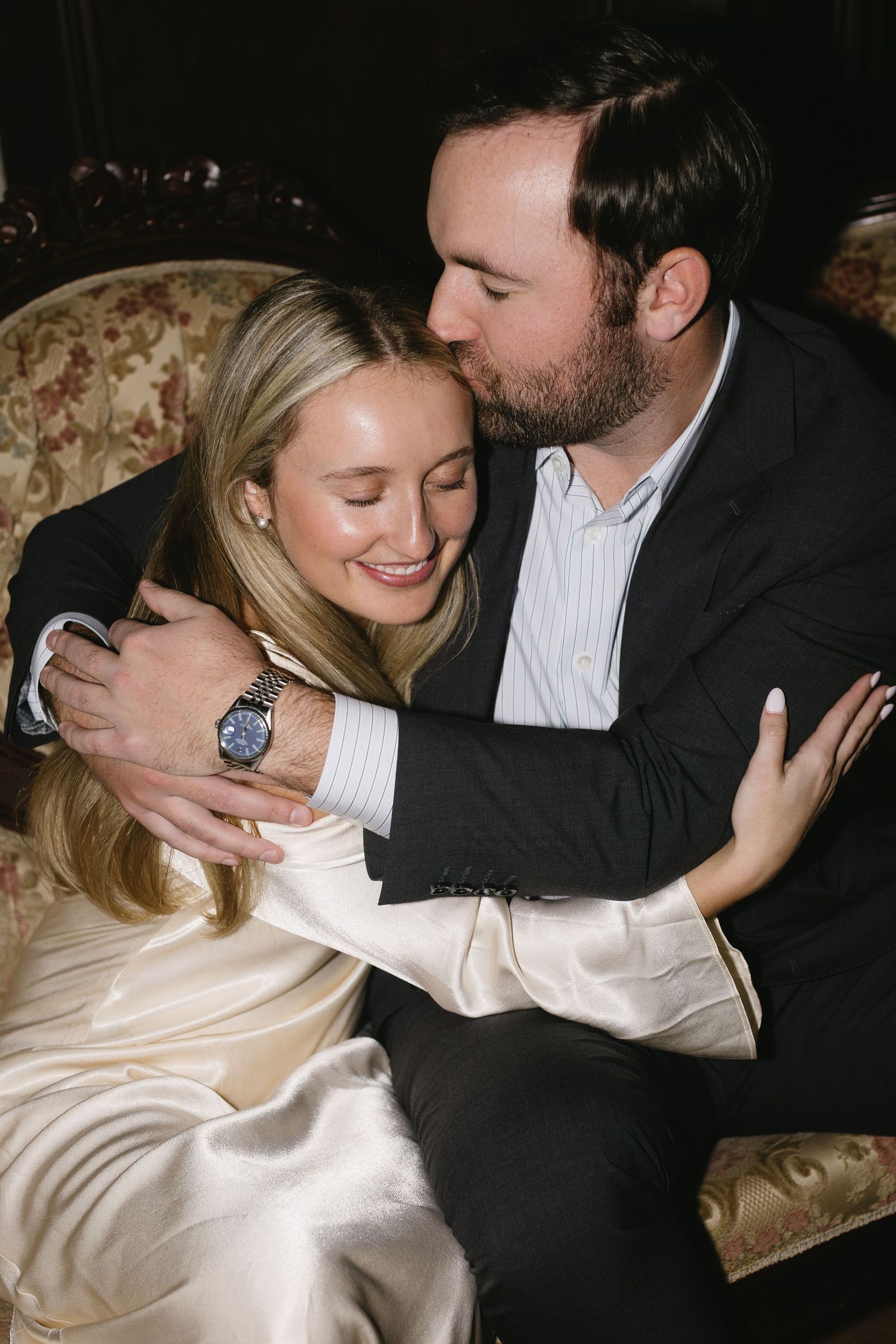 Intimate moment captured between a couple in formal attire at an elegant event.