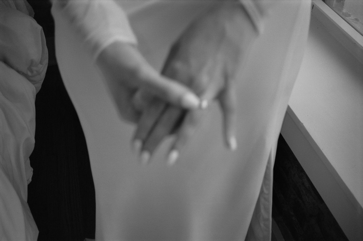 Black and white image of hands in motion against a blurred background.