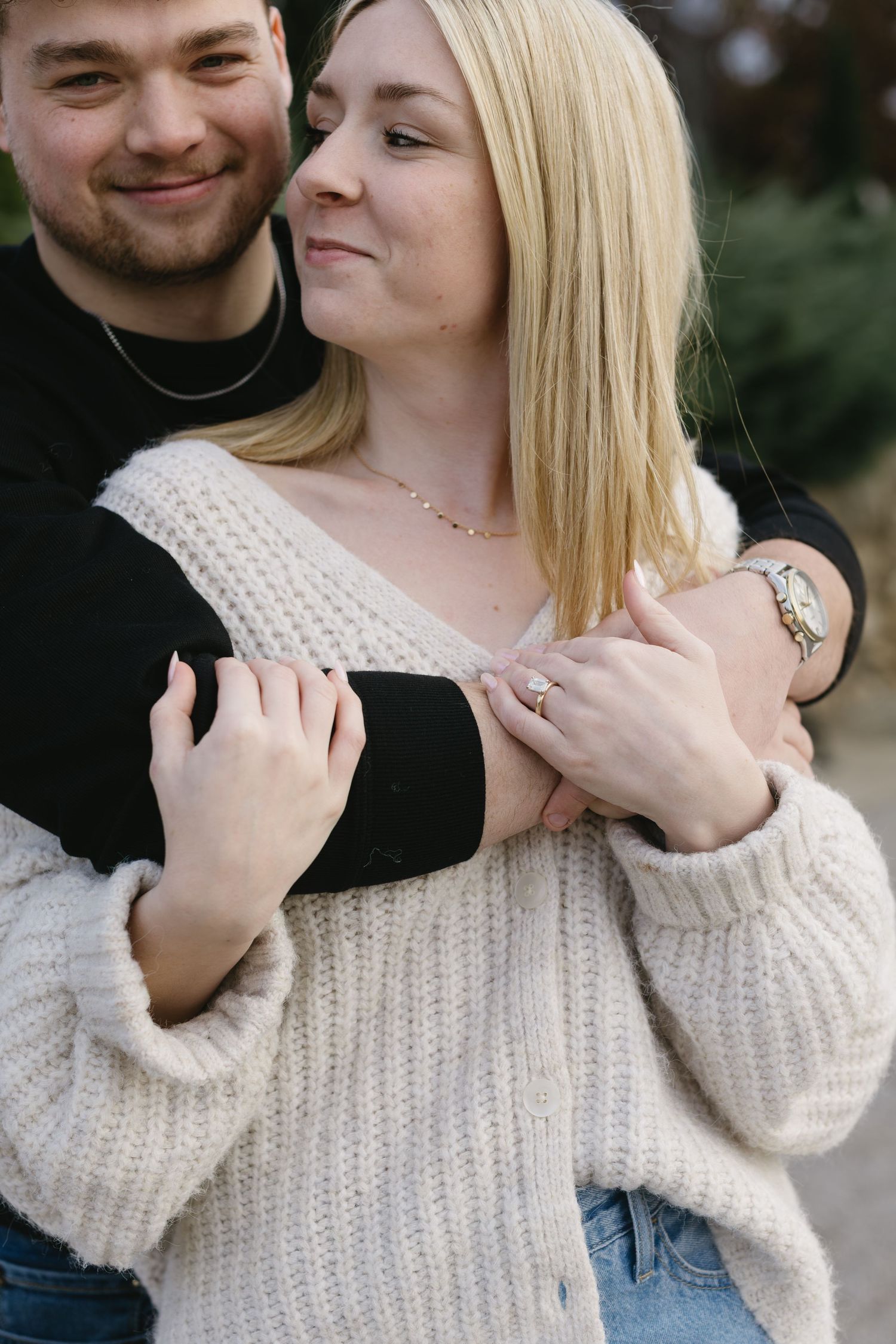 Close-up shots of a couple embracing while wearing a white knit sweater and black shirt.