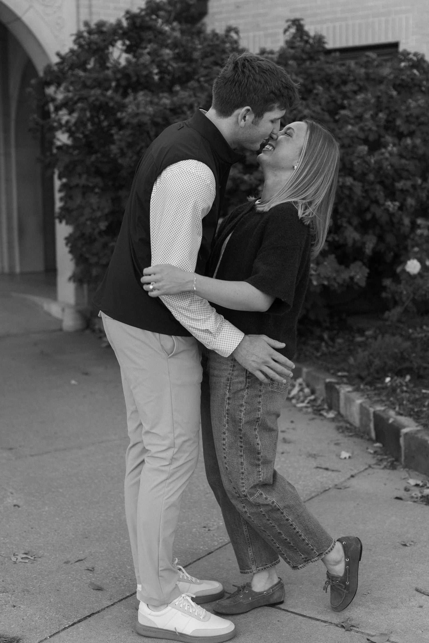 Black and white photo of a couple's feet during a romantic moment.
