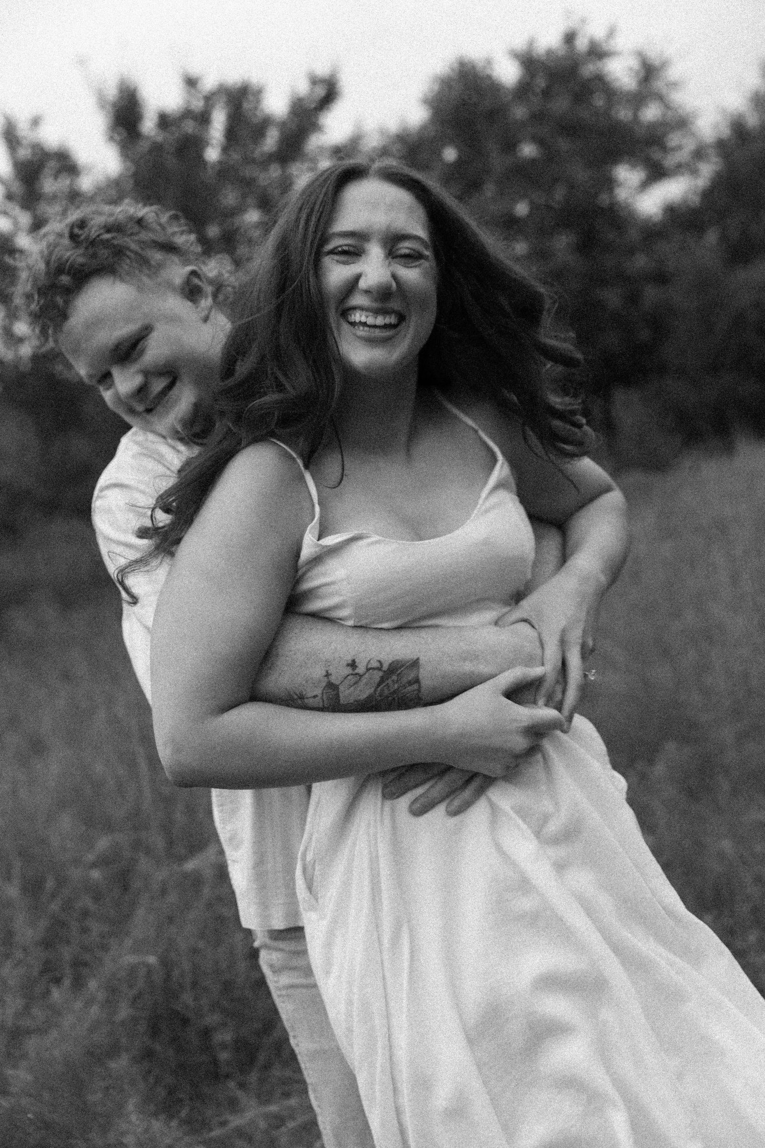 Black and white images of a couple laughing and embracing in an outdoor setting.