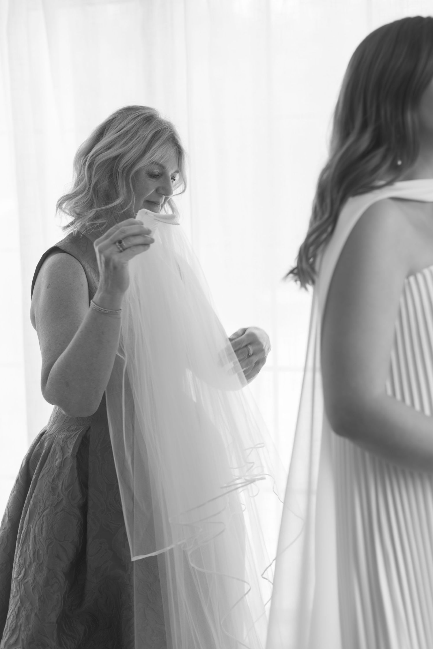 Artistic black and white silhouettes of wedding preparations in soft natural light.
