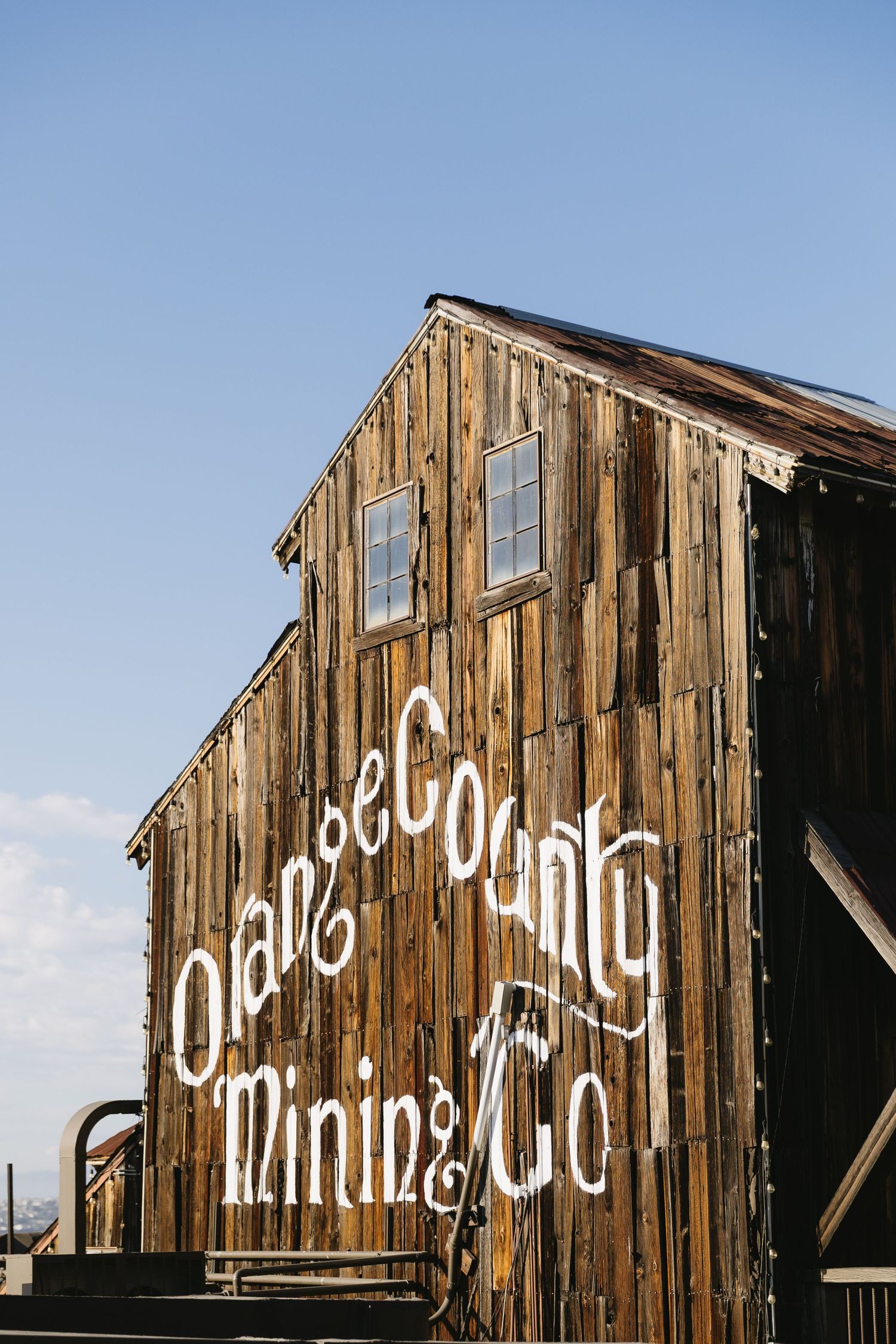 Weathered wooden barn exterior with vintage-style text painted on the side.
