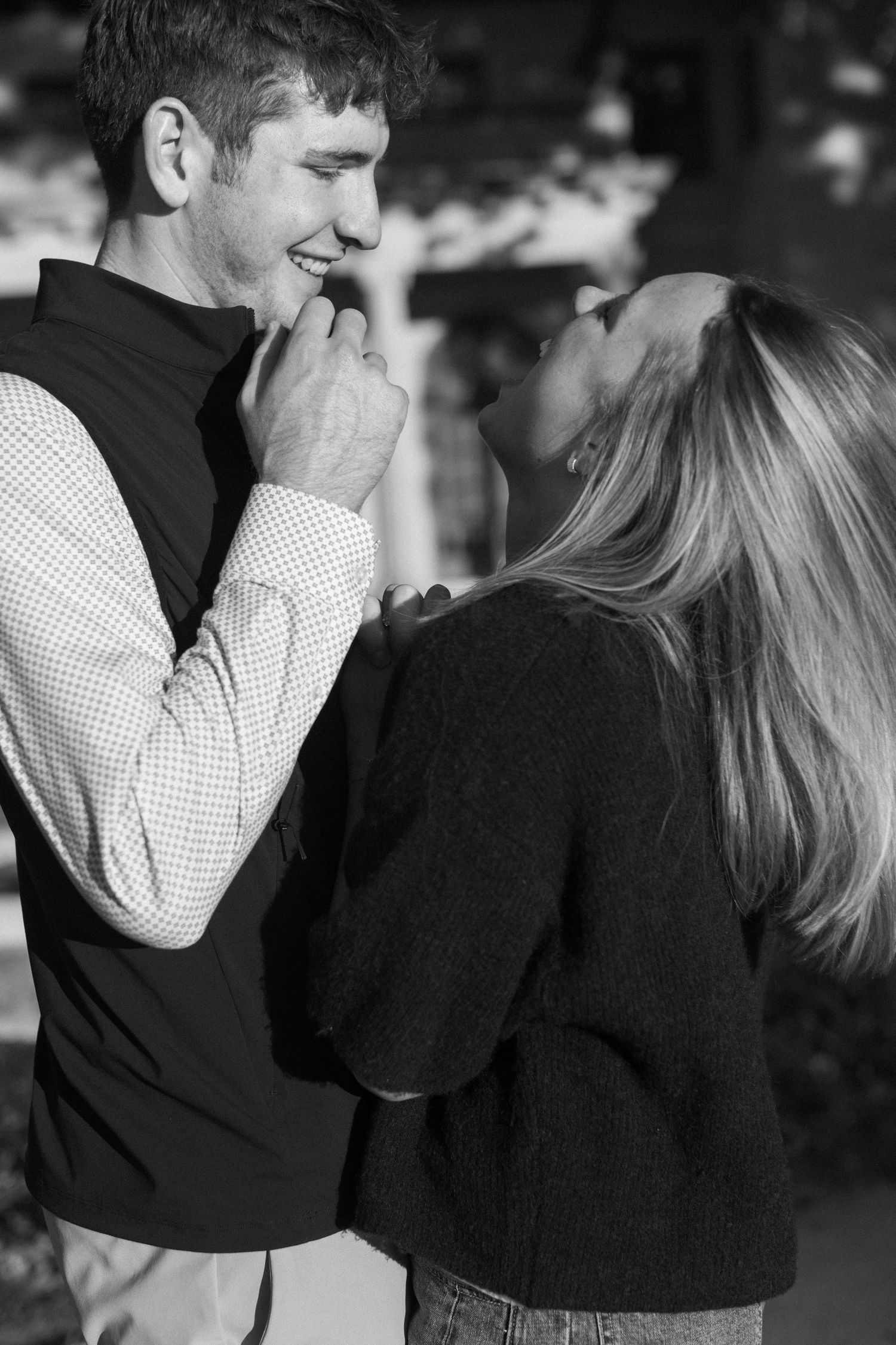 Close-up black and white photo of two people in an intimate moment wearing sweaters.