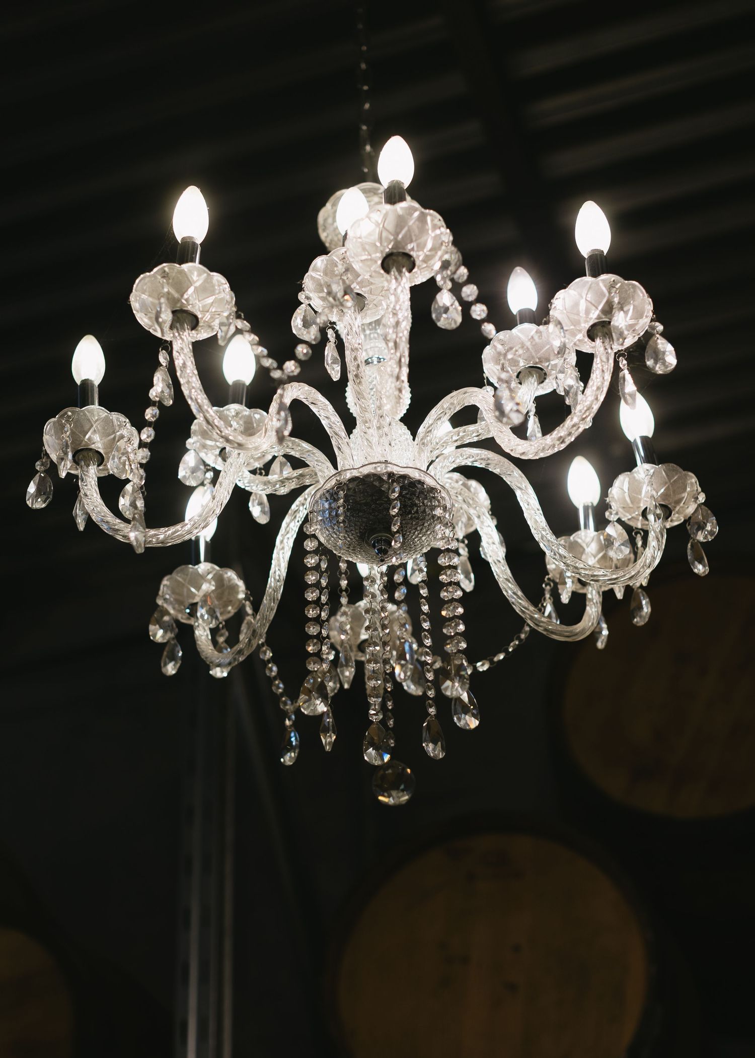 Crystal chandeliers with ornate details hang elegantly in a dark room creating a luxurious ambiance.