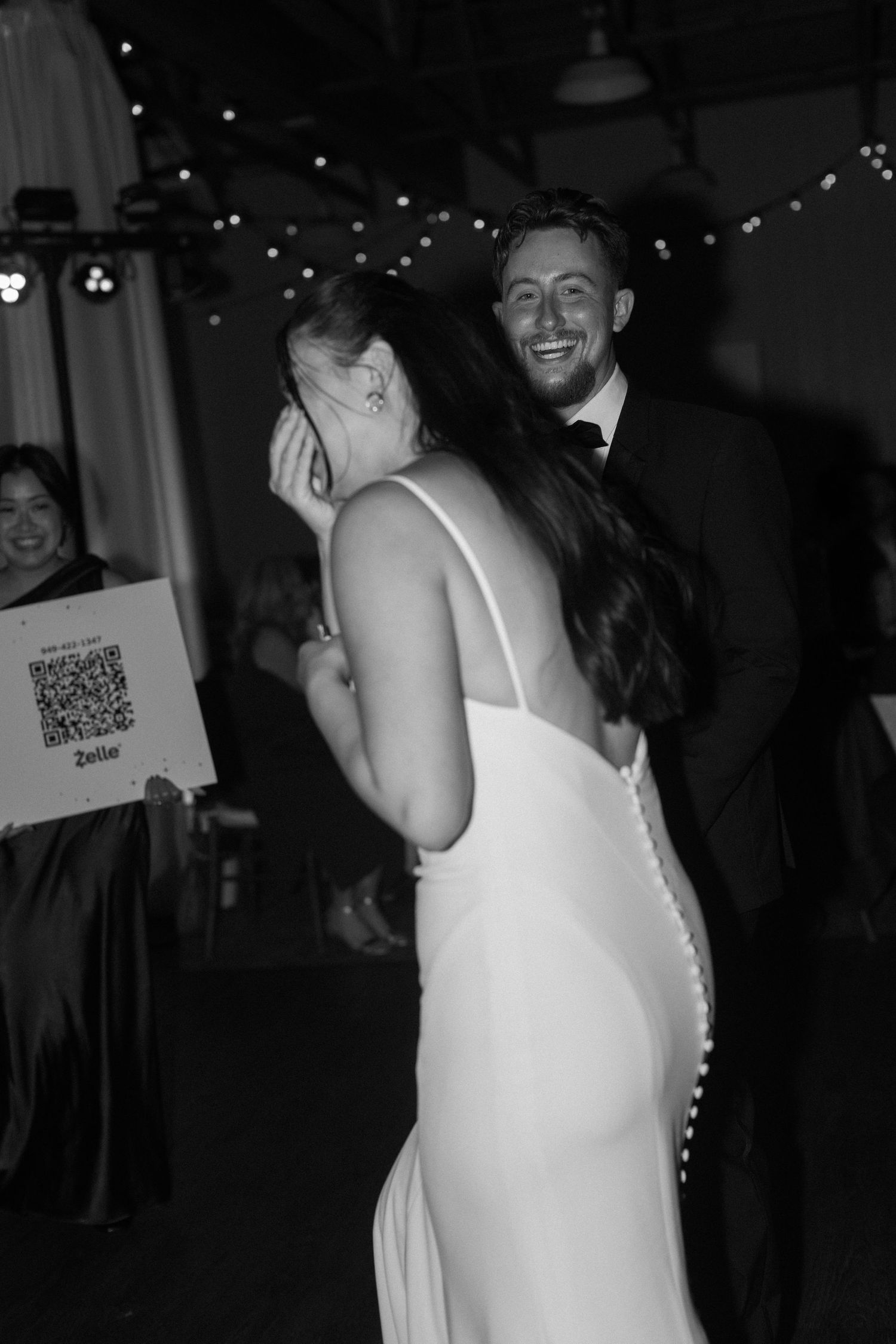 Black and white reception photos of guests dancing and celebrating at a wedding.