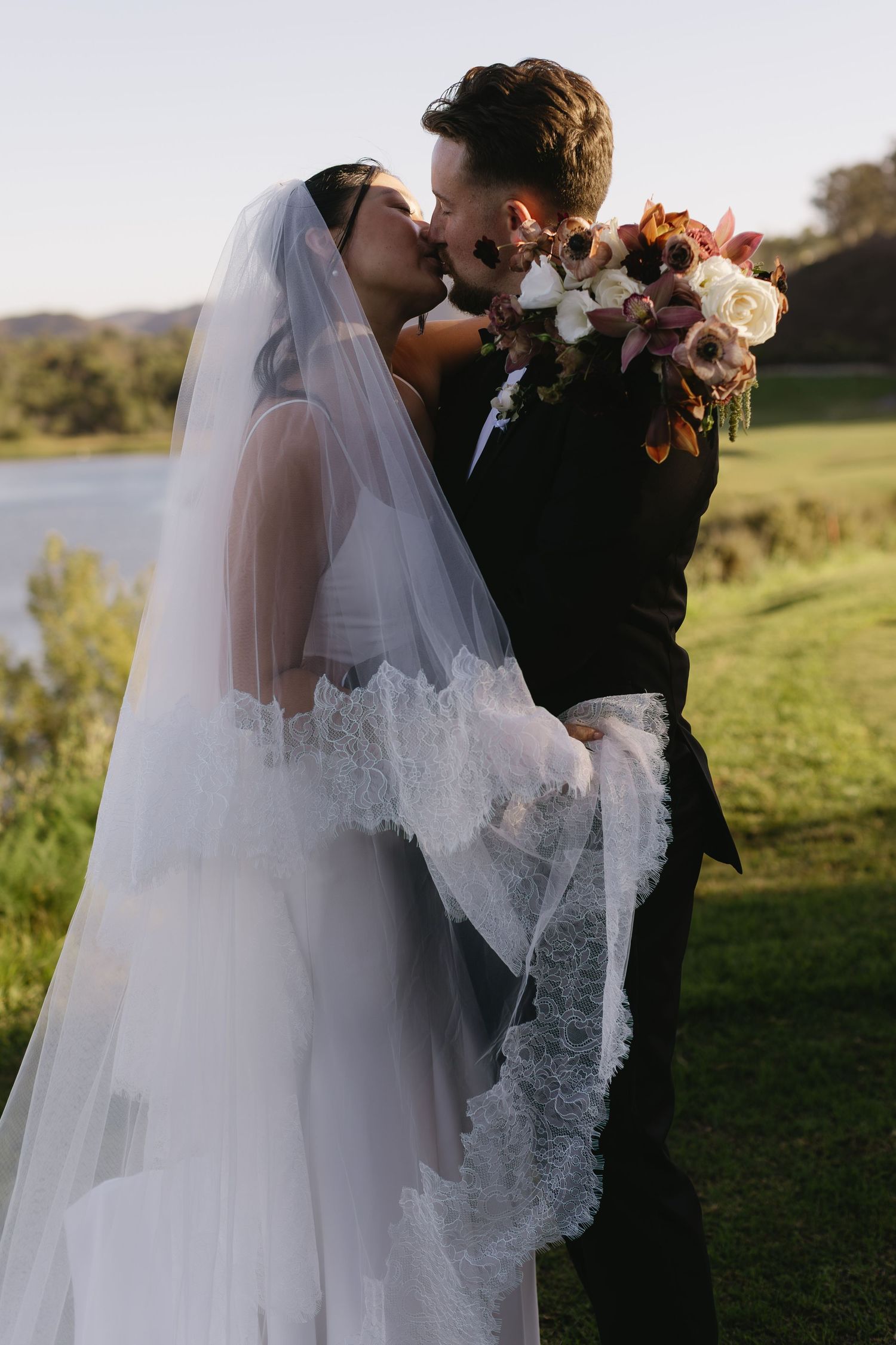 Romantic wedding portraits showing couple in elegant attire against natural outdoor setting.