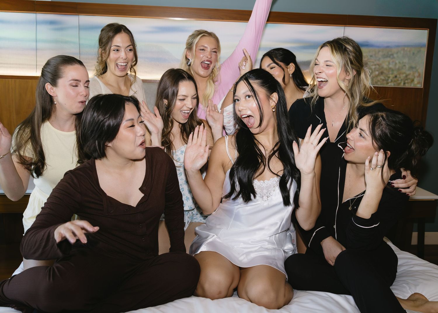 Friends share joyful moments and laughter while sitting together during wedding preparations.