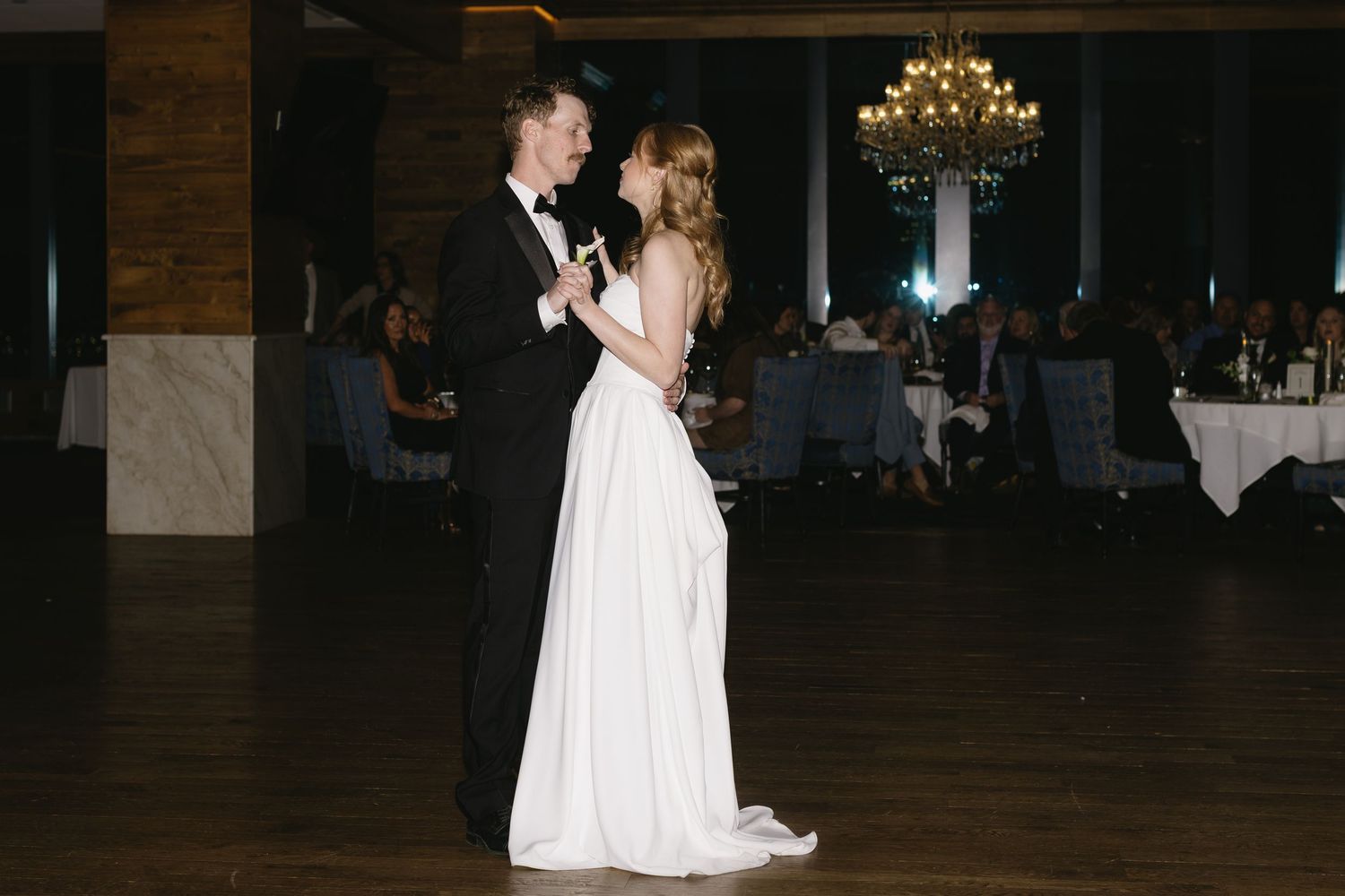 Wedding reception dance floor moments captured in dark ambient lighting.