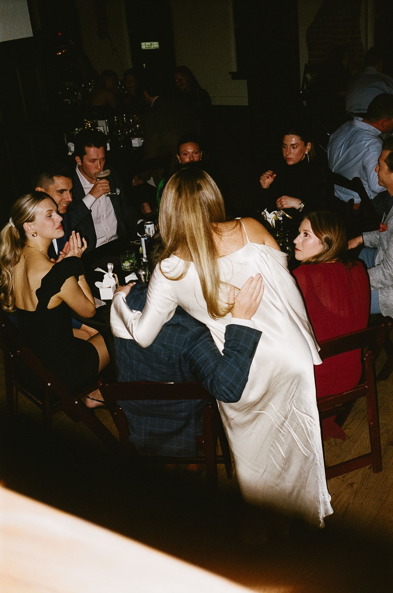Party guests socializing in a dimly lit venue space.