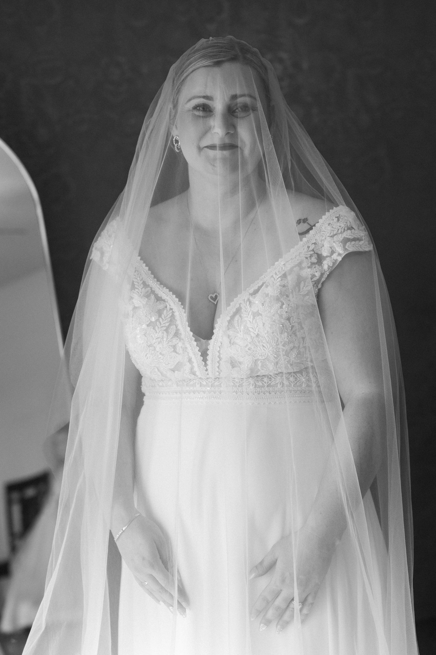 Close-up details of a white lace wedding dress with delicate veil.