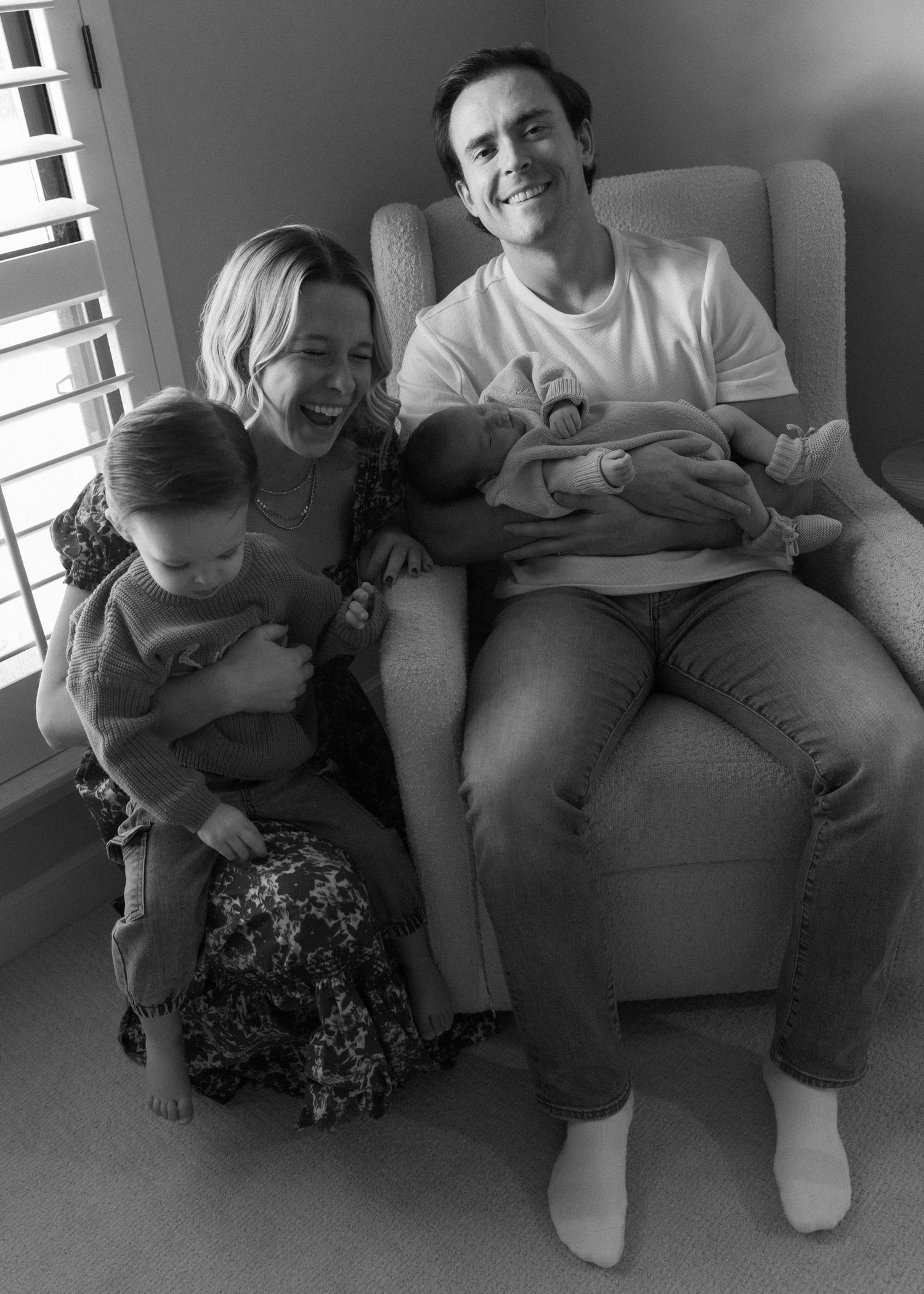 A black and white series of photos showing a family relaxing together on a couch.