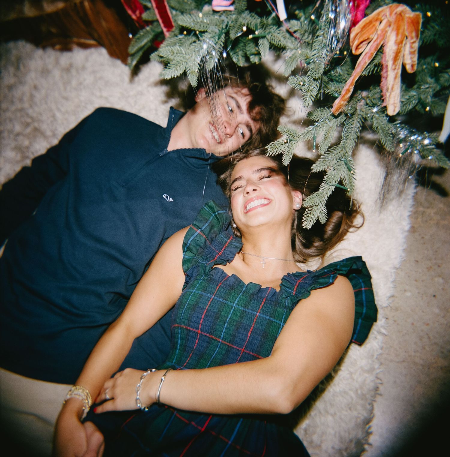 A person lies on the floor laughing near a Christmas tree in a series of candid festive moments.