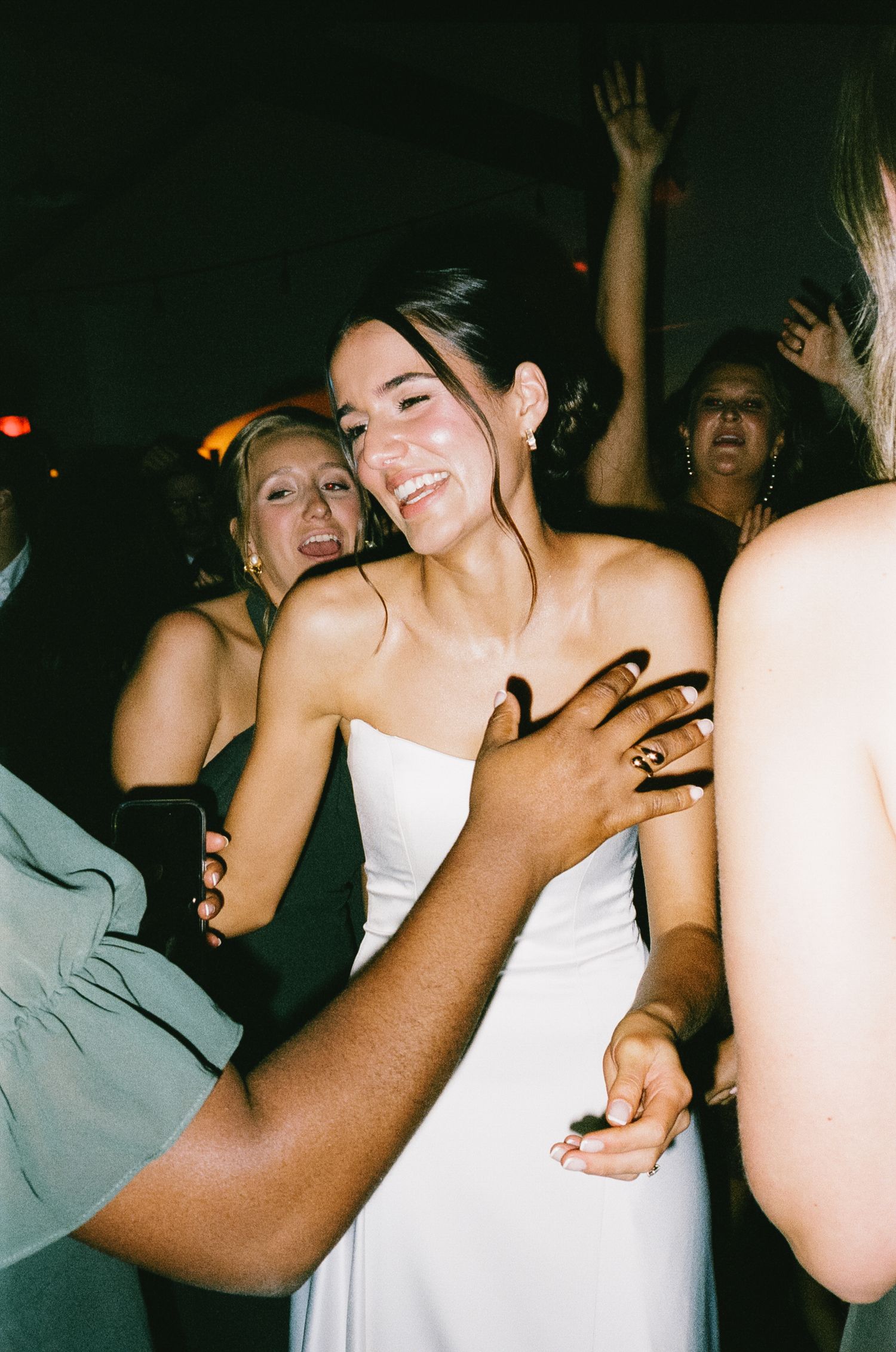 Wedding celebration on dance floor with joyful dancing and laughter.
