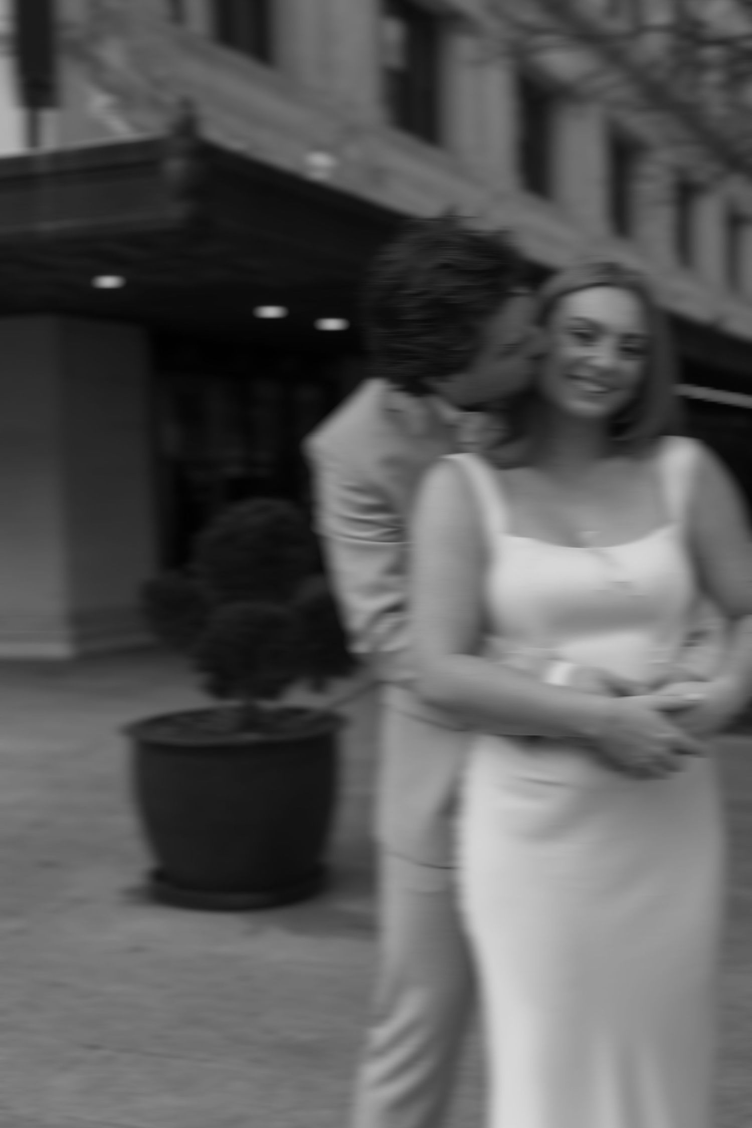 A blurred candid moment between a couple in formal wear outdoors.