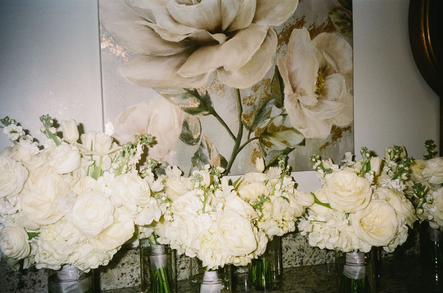 Elegant white roses and floral arrangements with delicate greenery for wedding decor.