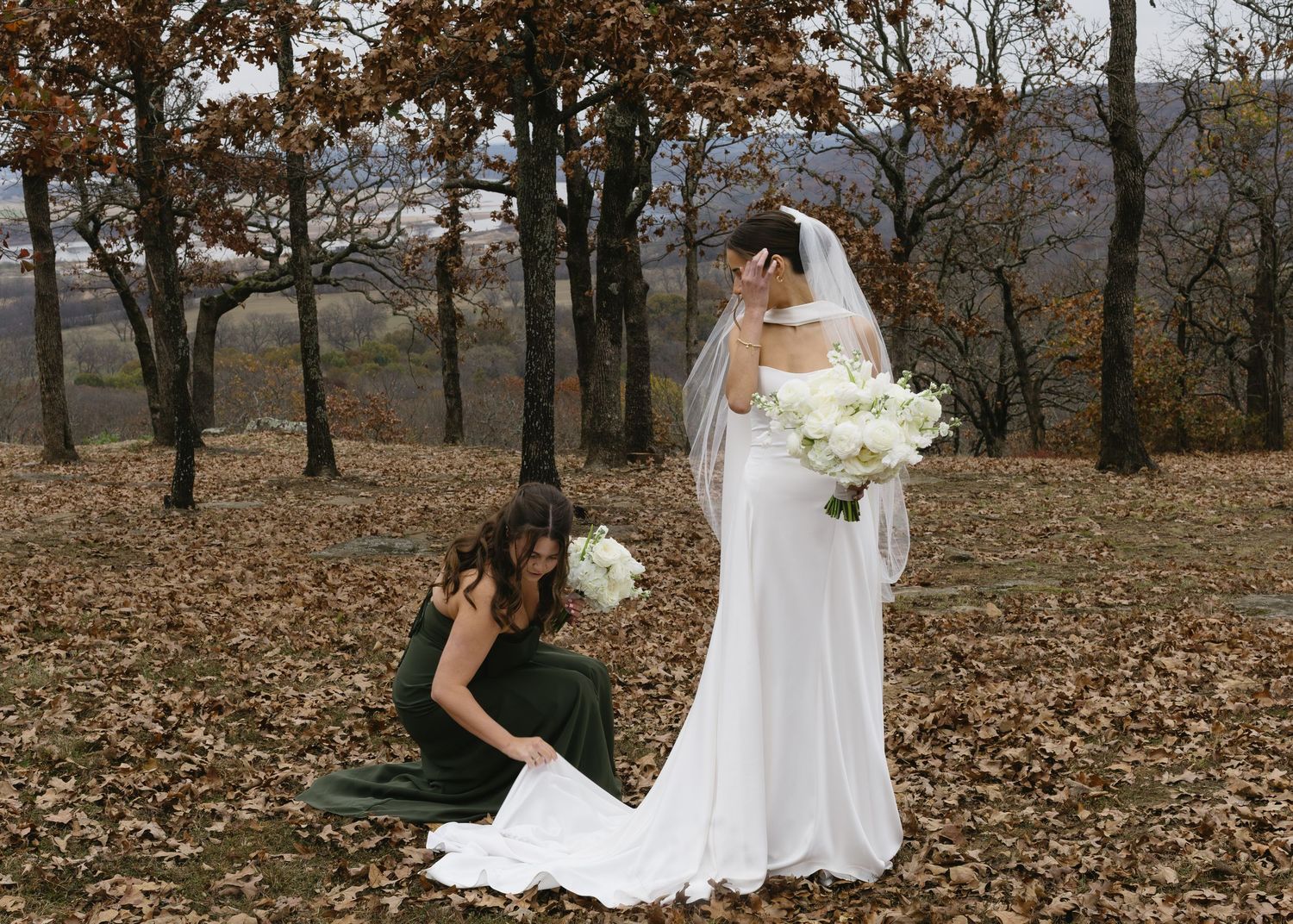 Wedding party poses among autumn trees during outdoor celebration.