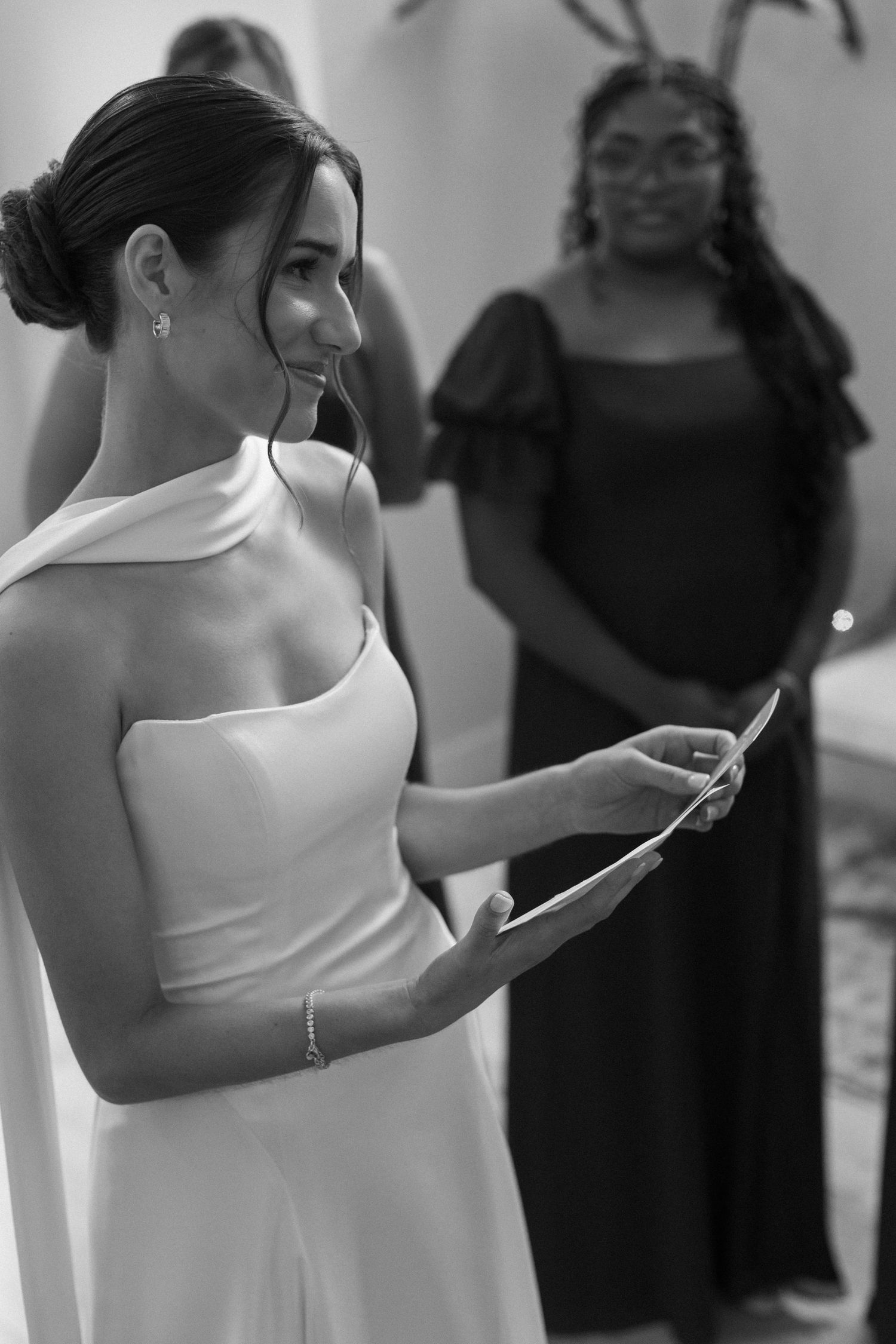 Black and white photo of wedding preparation moments with elegant white dresses.