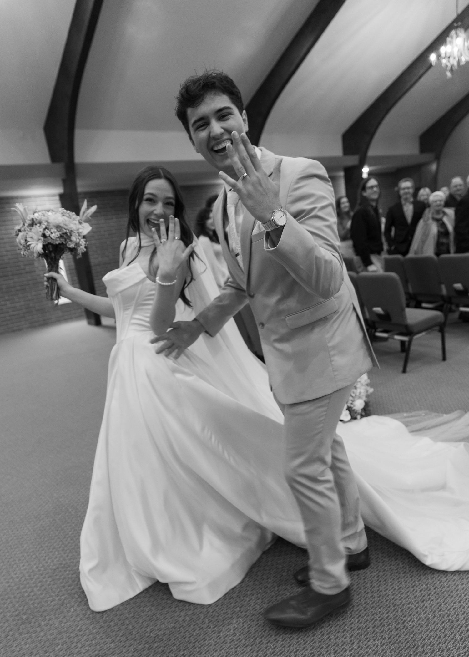A playful wedding couple in white dress and tan suit poses on carpet in a sequence of fun dance-inspired photos.