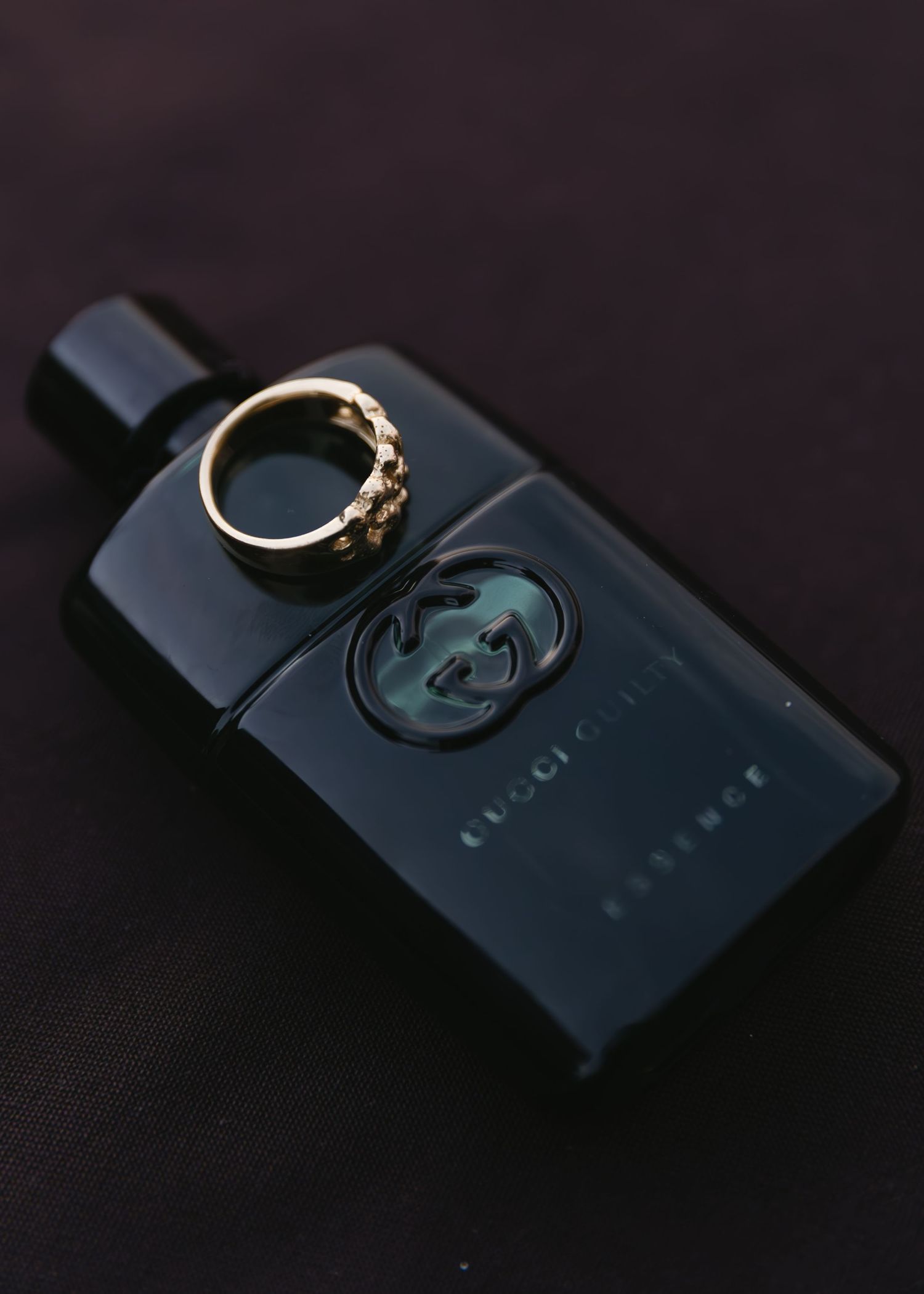 Wedding rings displayed on dark surfaces in dramatic lighting.