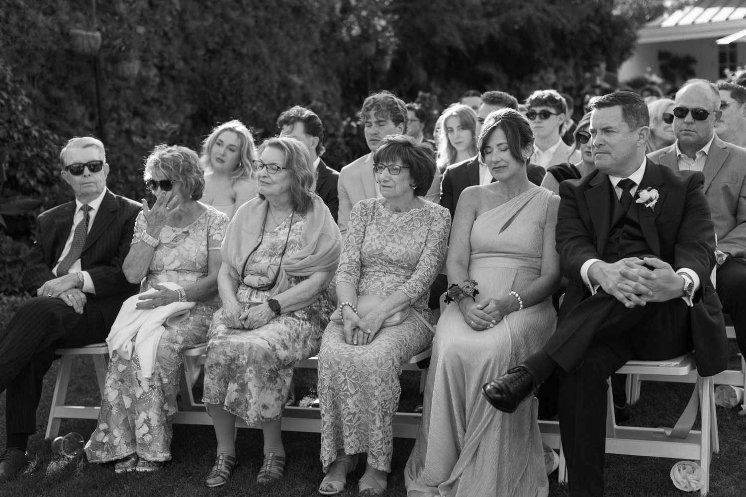 A black and white photo montage showing people watching and reacting at what appears to be an outdoor event.
