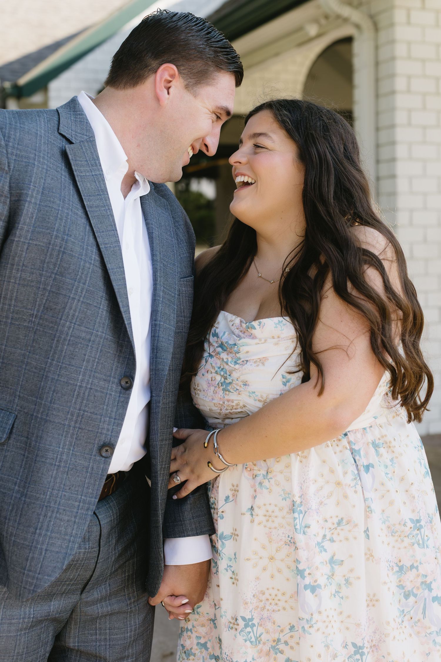 Romantic couple dressed in gray suit and floral dress share intimate moments in four sequential outdoor photographs.