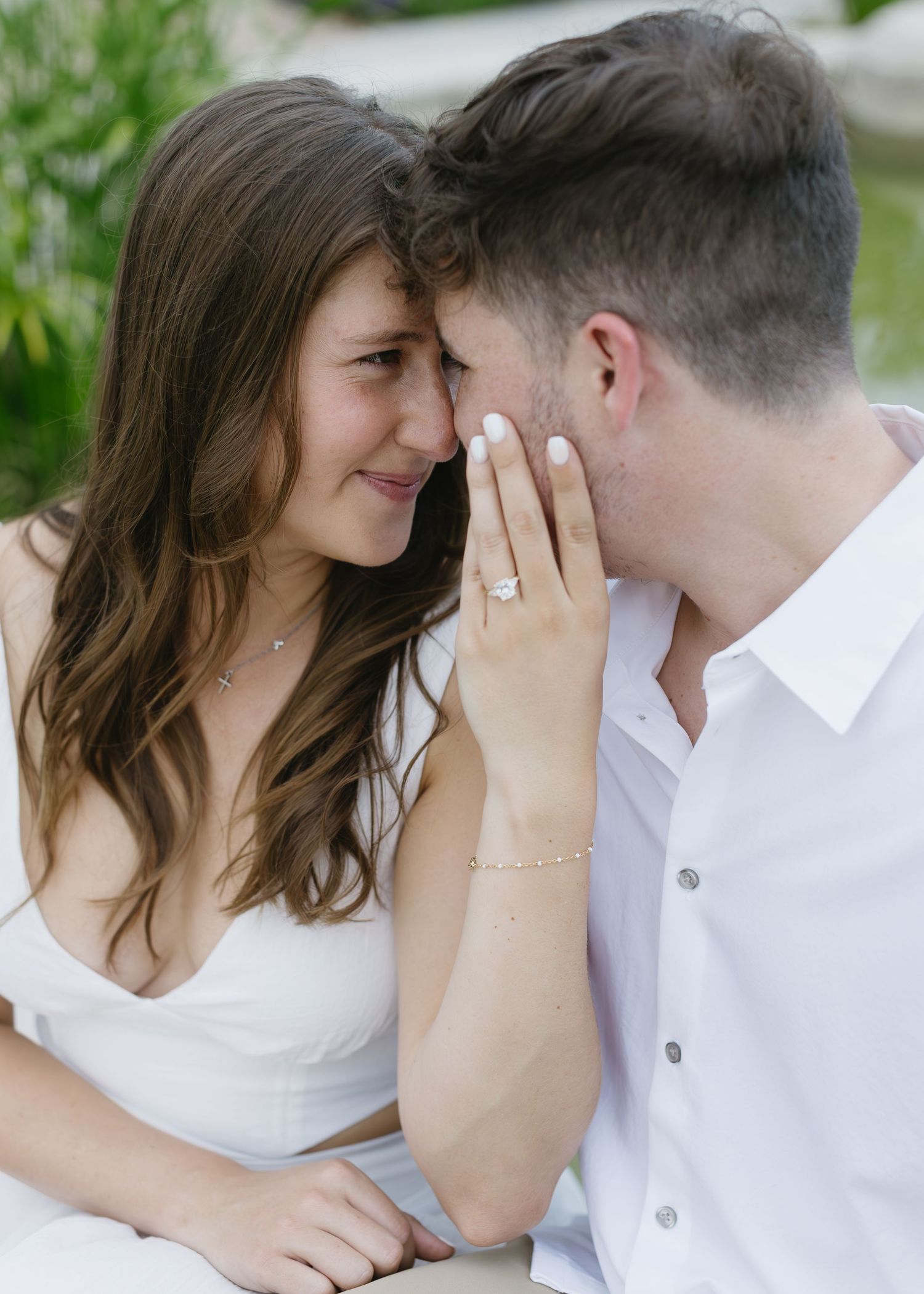 An intimate close-up moment captured between a couple in white summer attire.