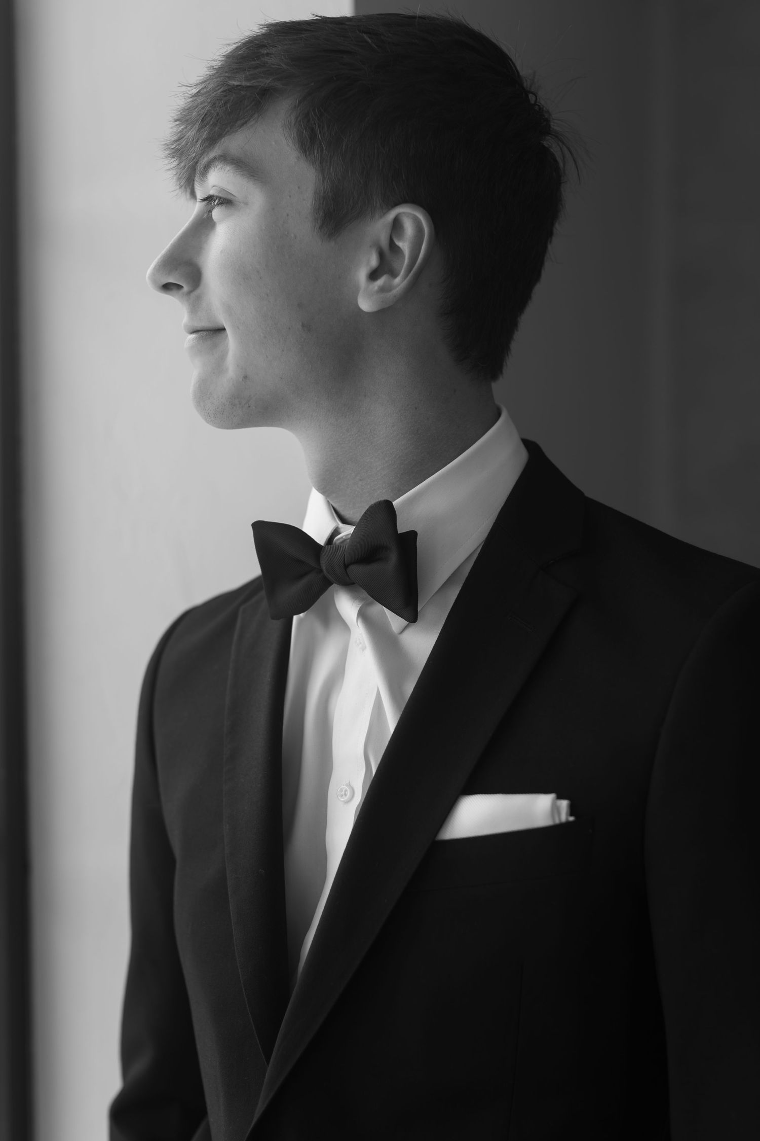 Artistic black and white portrait of someone in a formal tuxedo and bowtie.