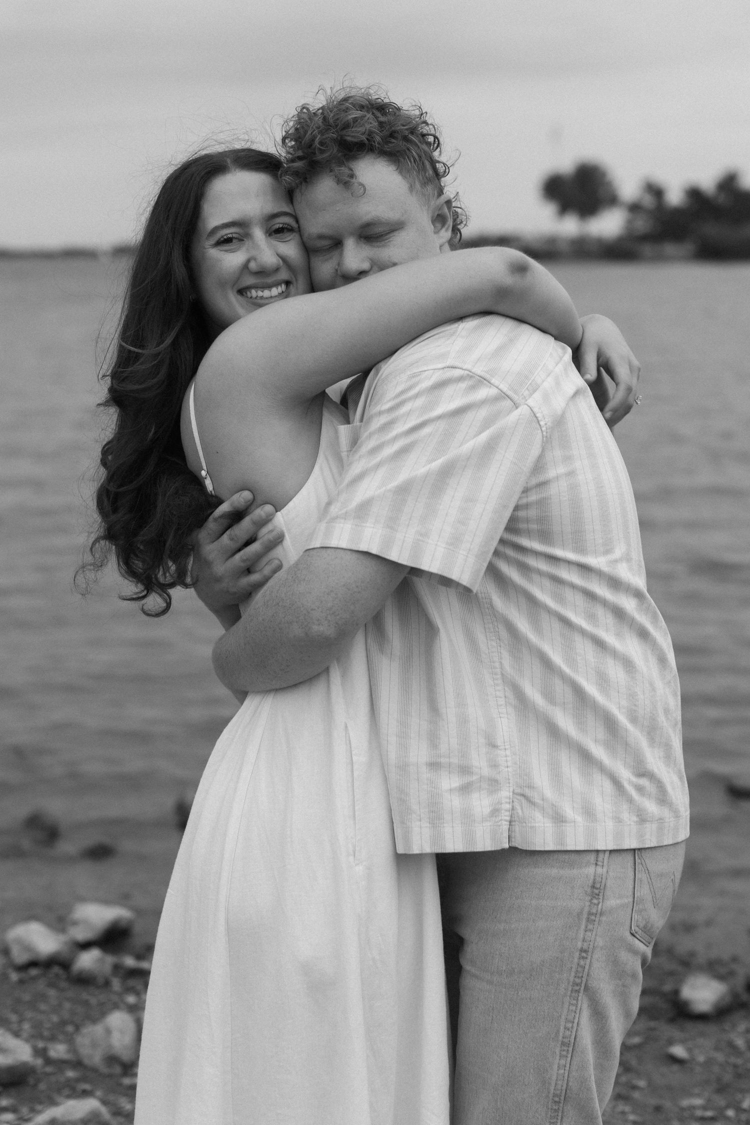 A romantic black and white photo series showing an intimate embrace on the beach.