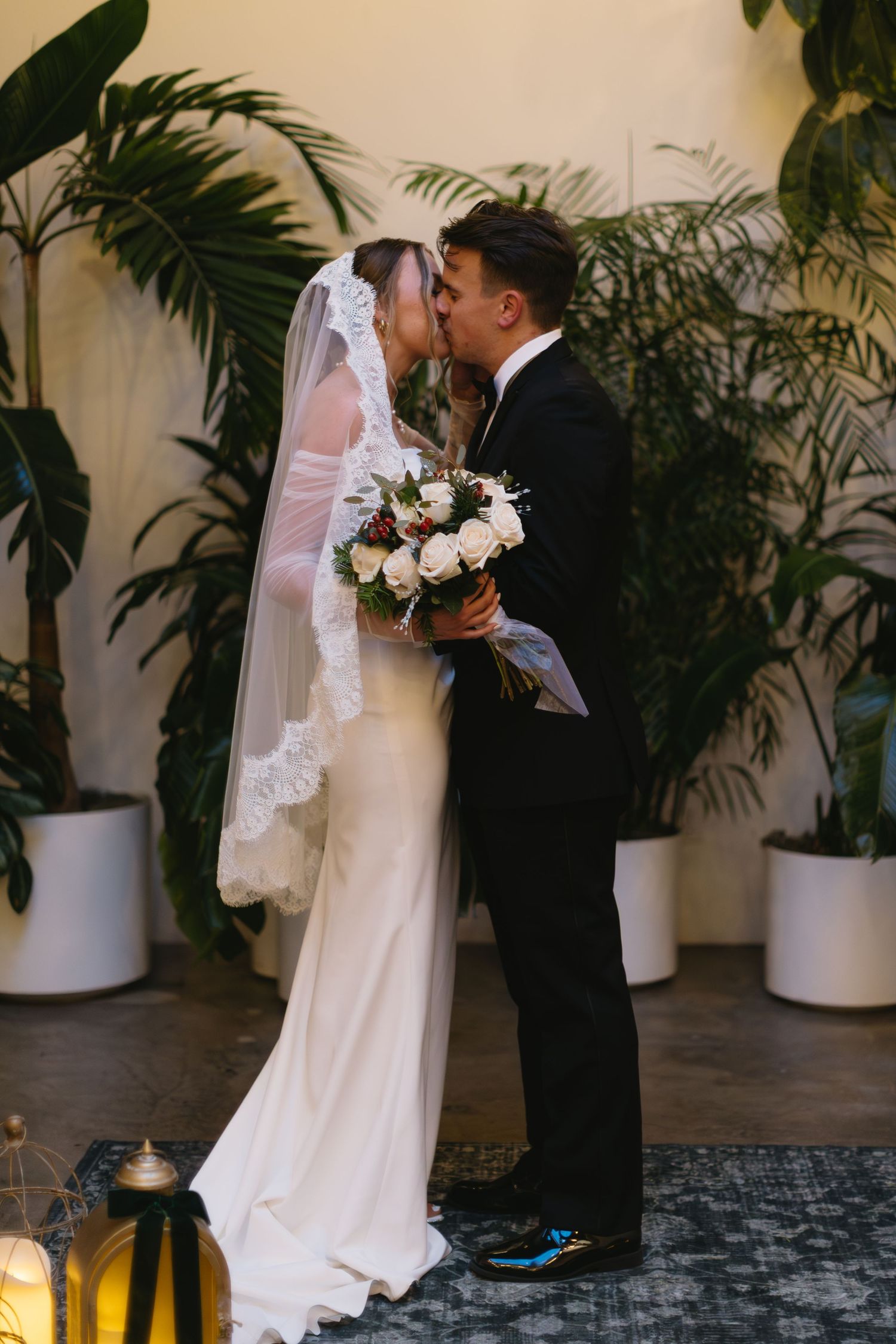 Romantic wedding portraits with tropical plants and soft lighting creating an intimate atmosphere.