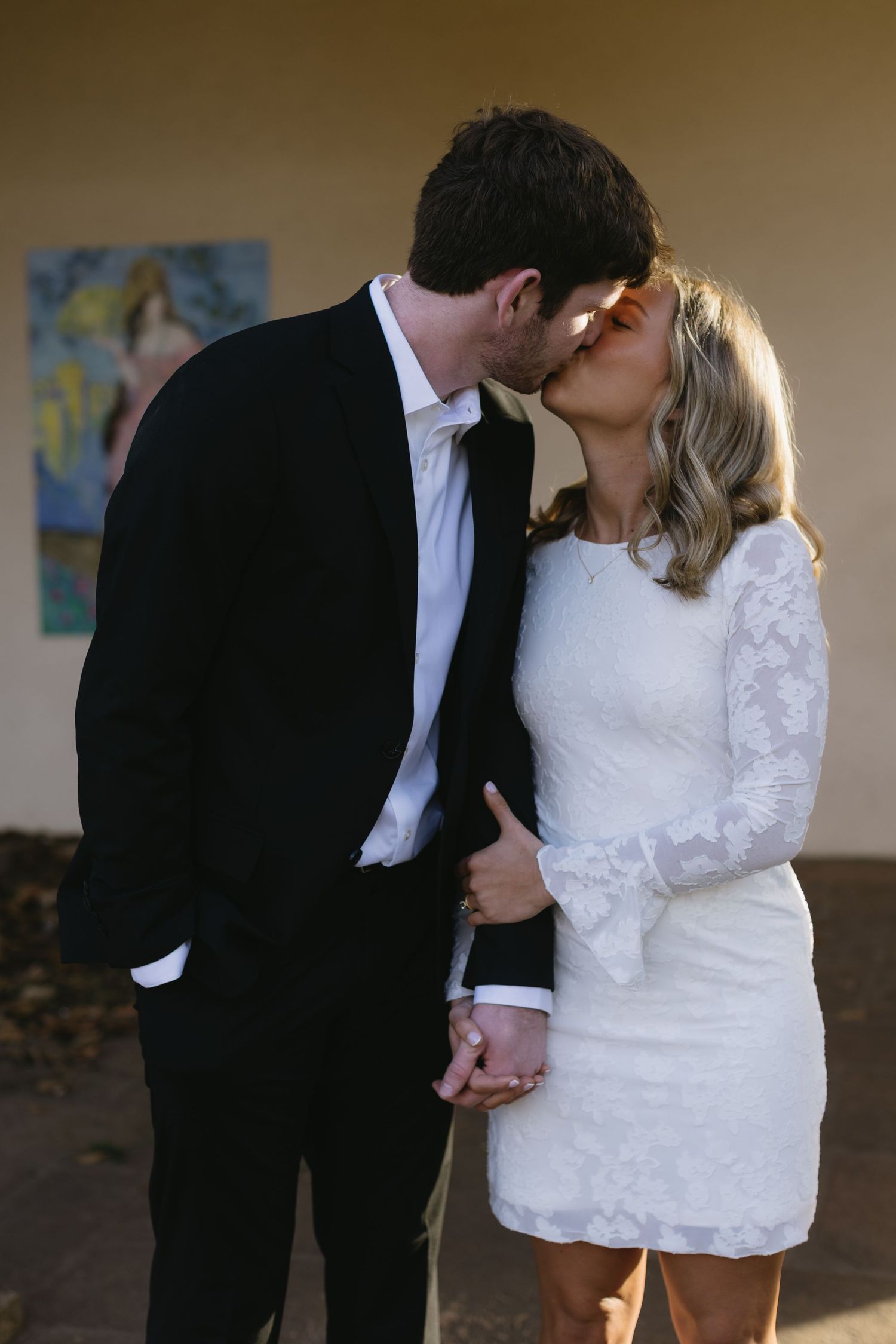 A tender moment between newlyweds in classic black and white wedding attire.