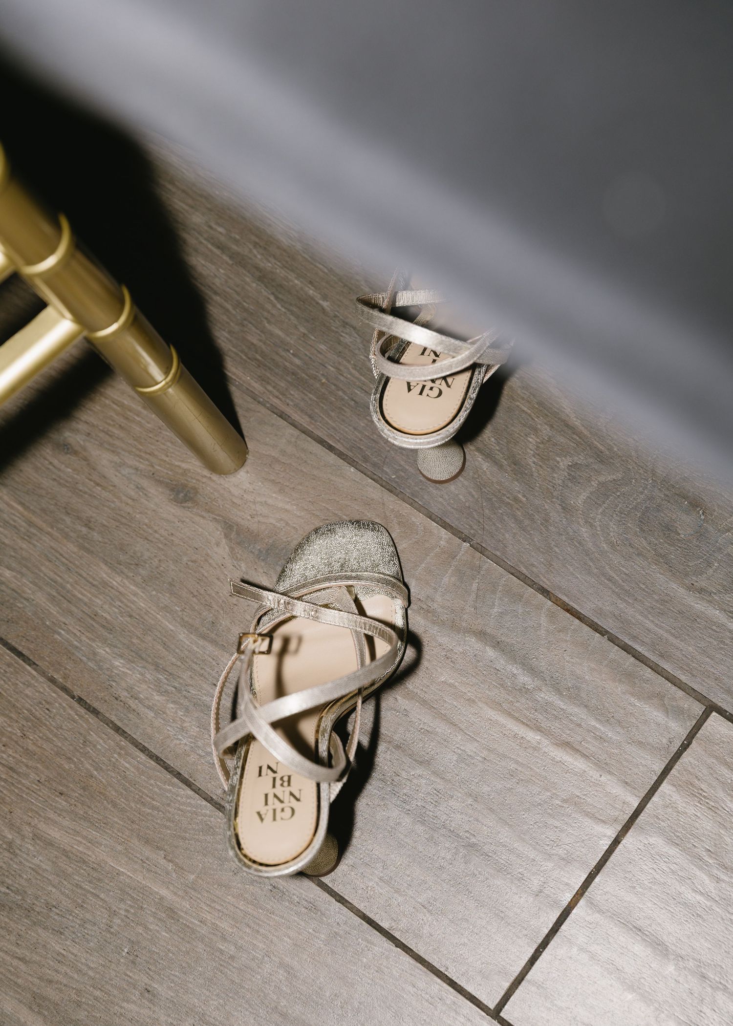 Wedding shoes scattered on a wooden floor during a reception celebration.