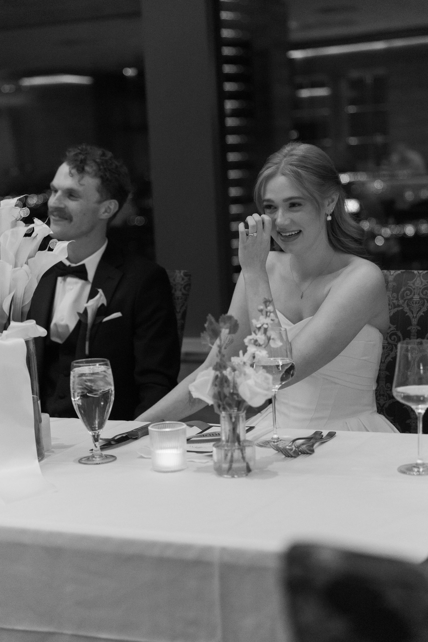 Wedding reception candid moments at an elegant dinner table with candlelight.
