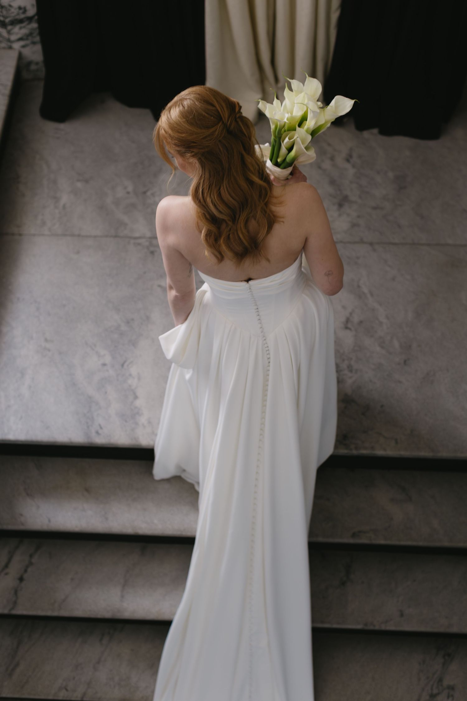 Back view of white wedding dress with delicate details and floral accents.