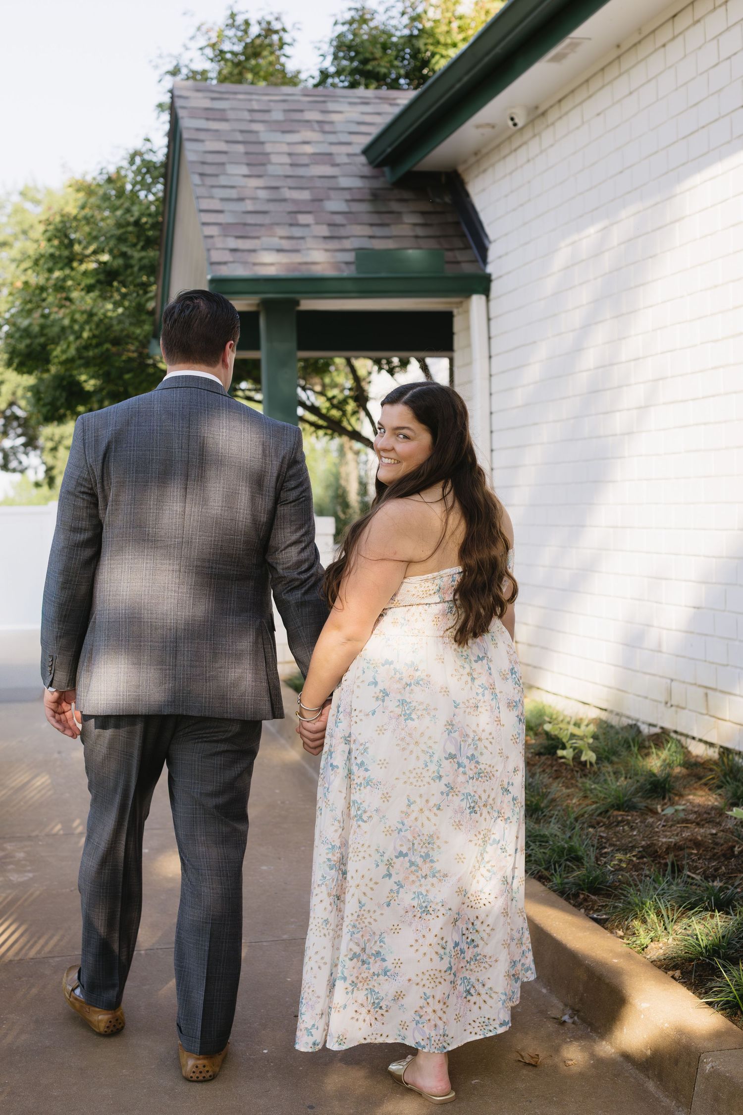A couple in formal attire poses against a white building wall in a series of candid shots.