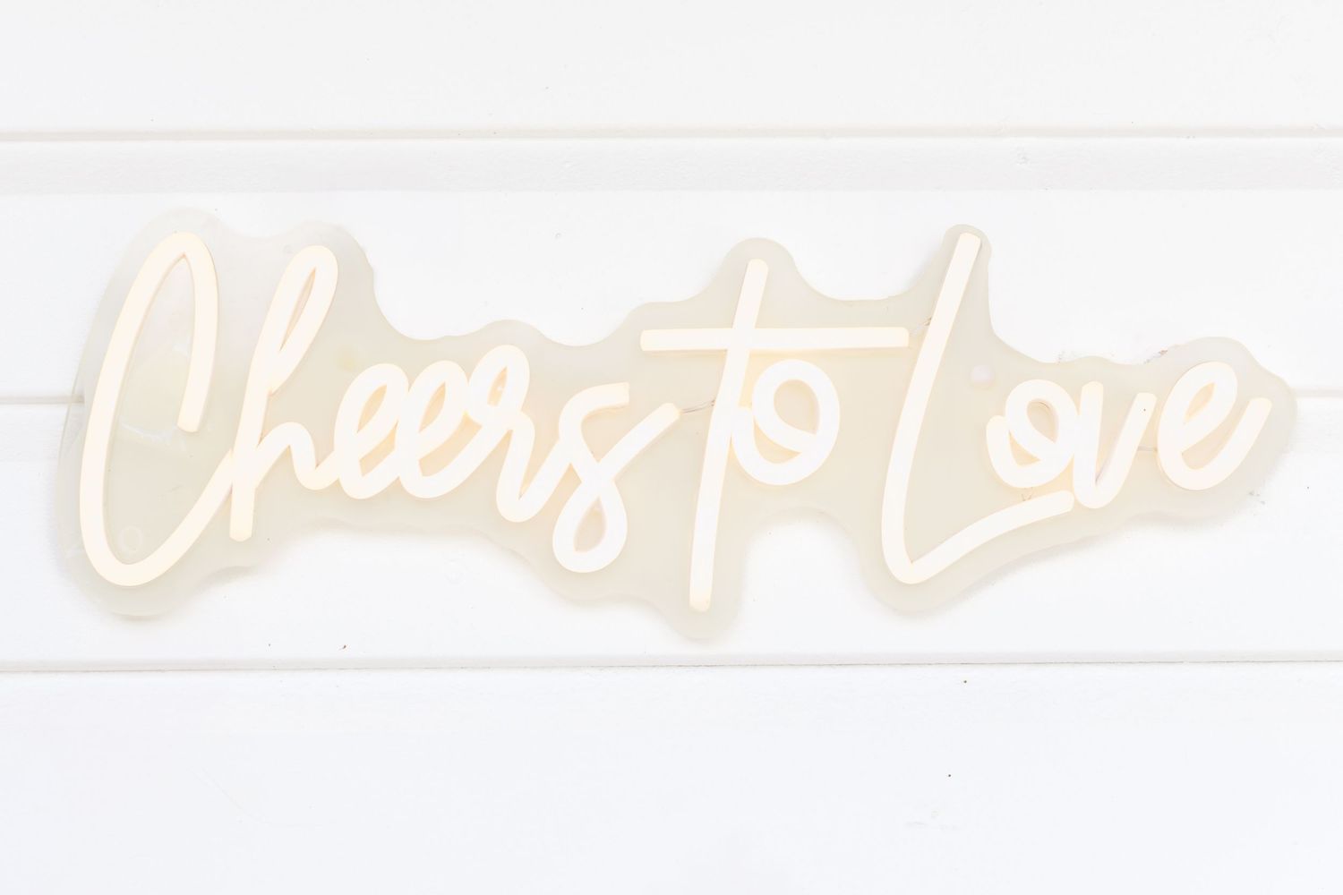 Decorative neon sign display with soft illumination against white background.