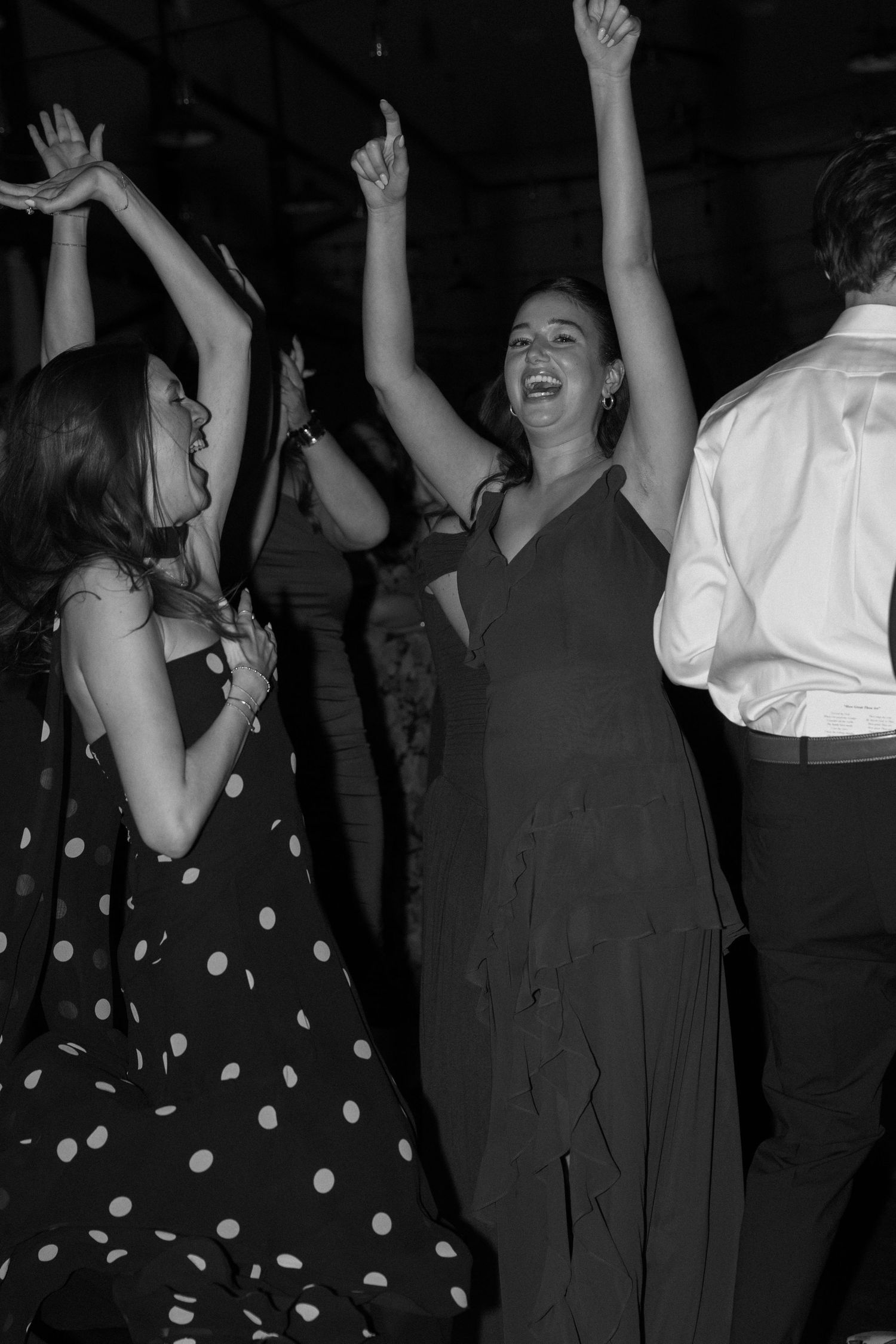 Wedding guests dancing and celebrating on the dance floor in black and white.