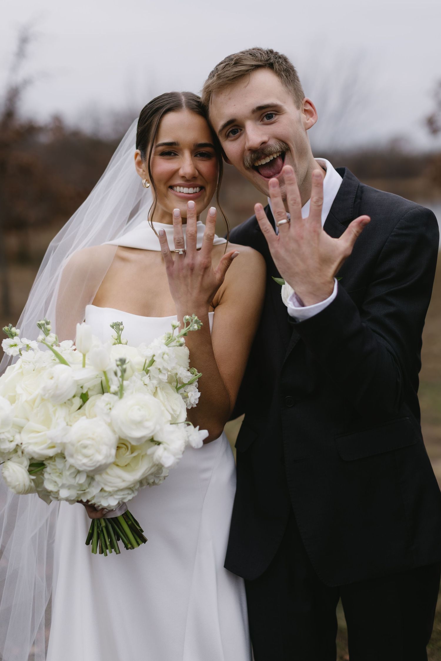 Elegant white wedding bouquet with roses displayed against formal wedding attire.