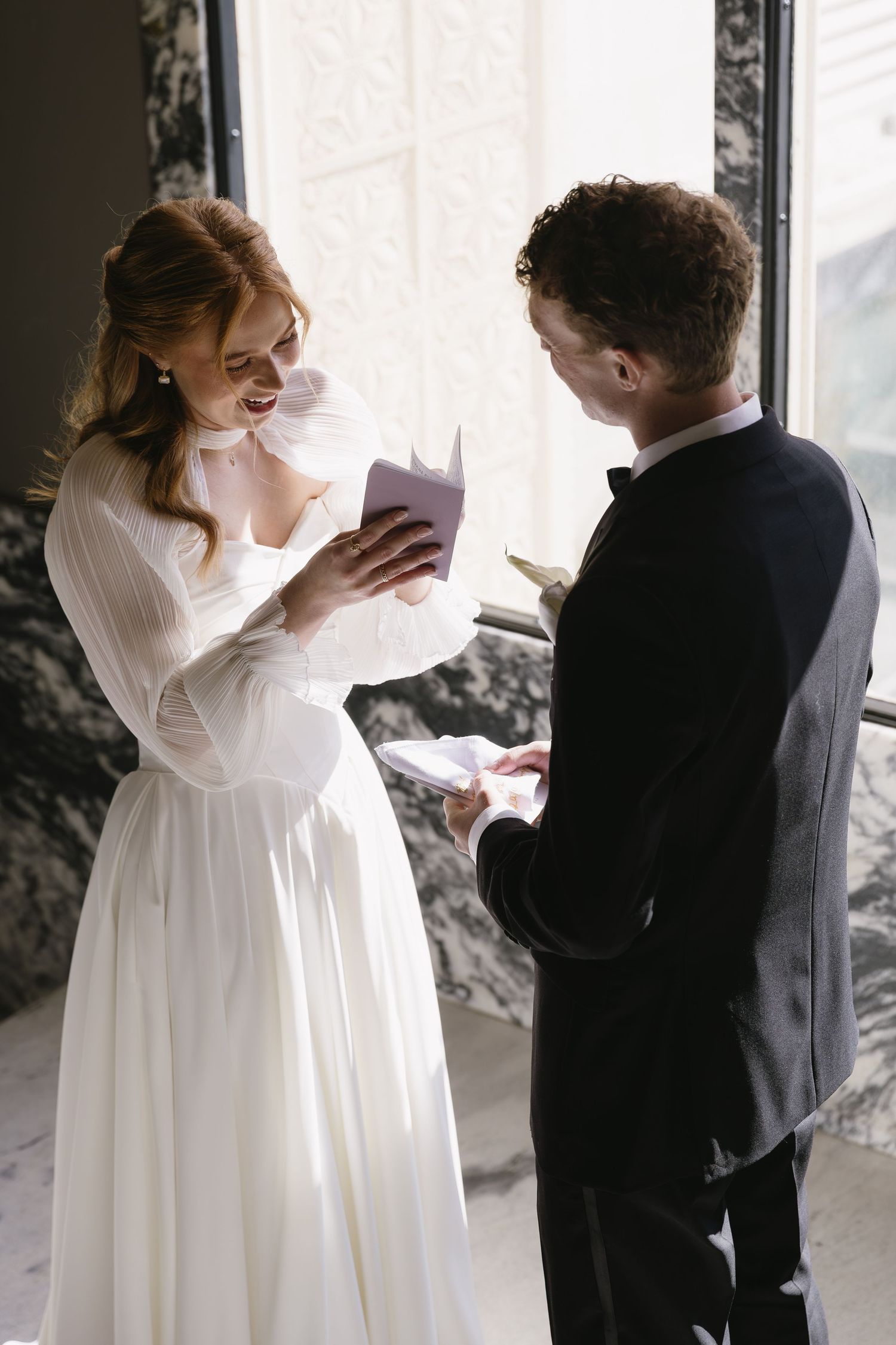 A tender wedding moment captured between two people in white and black attire.