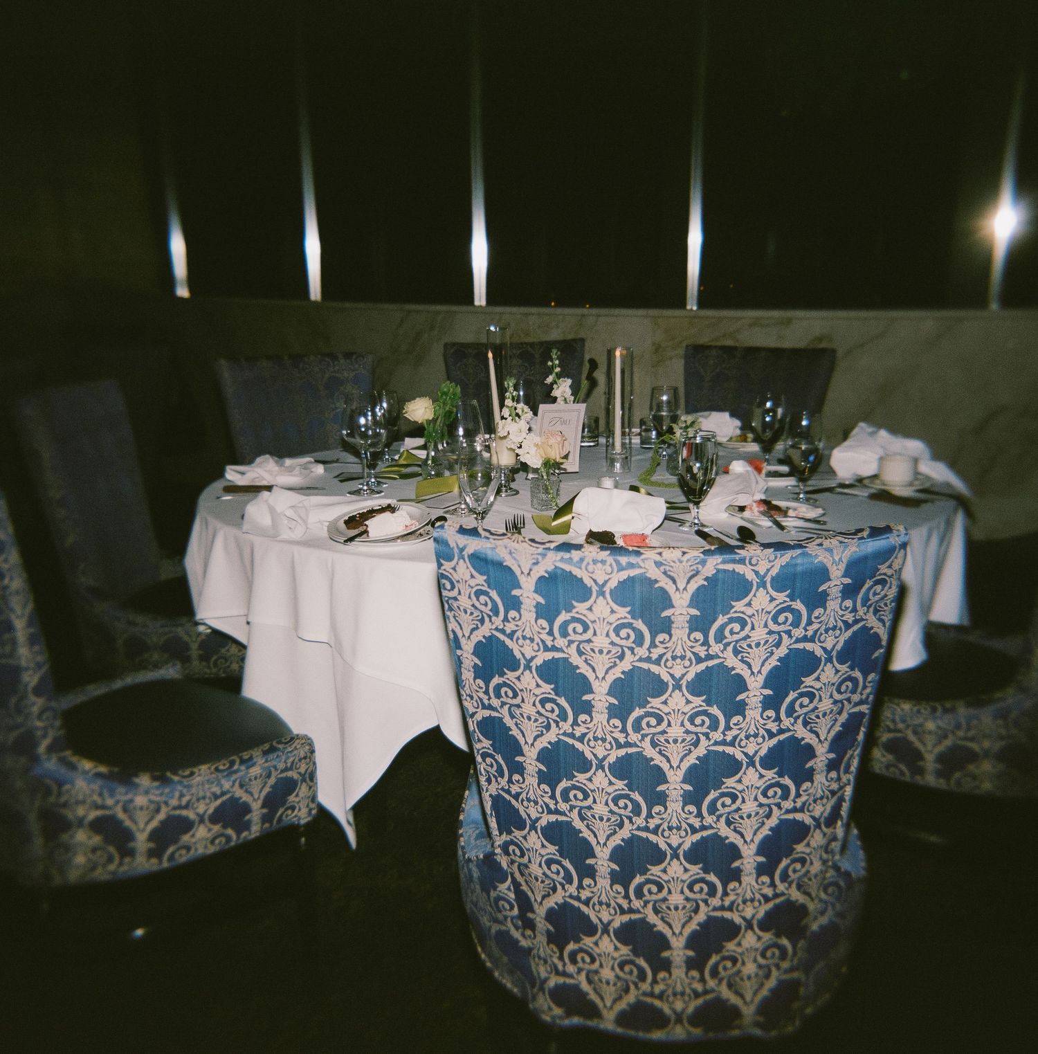 Reception tables decorated with elegant blue and white damask tablecloths.