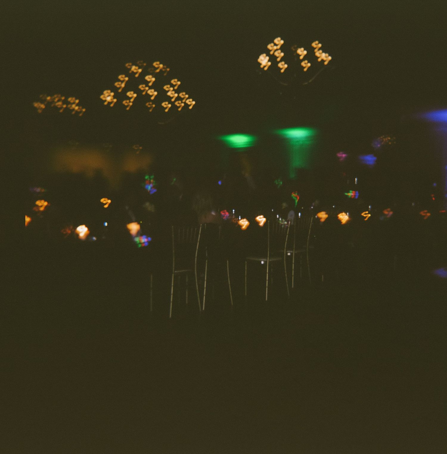 Decorative hanging lights create a romantic ambiance at an evening outdoor wedding venue.